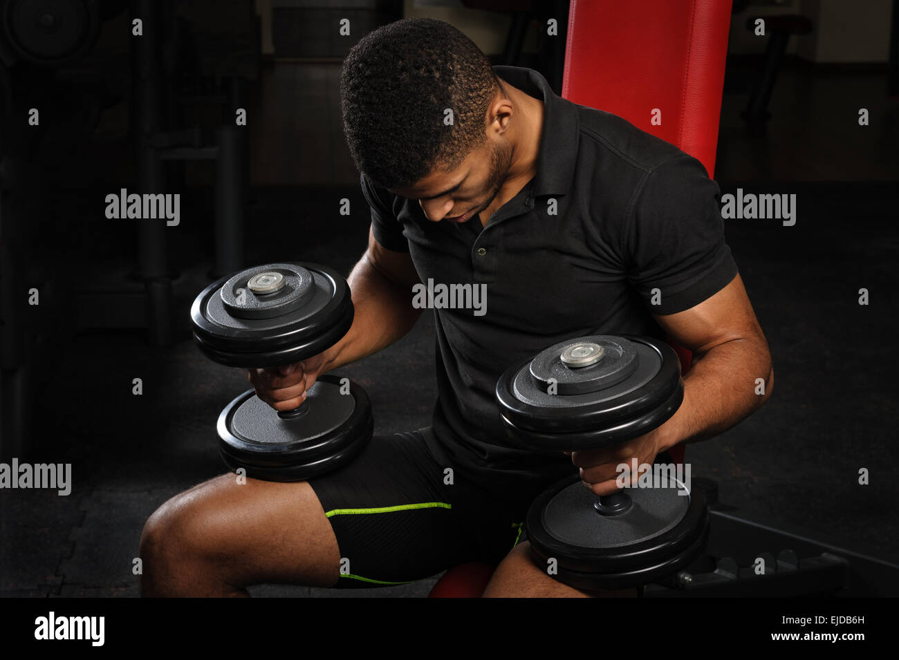 young man sitting on bench at gym Stock Photo