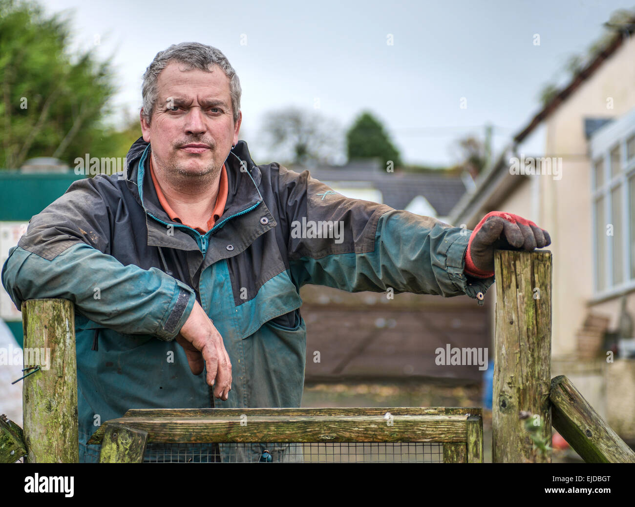 Hard working man resting on a gate Stock Photo