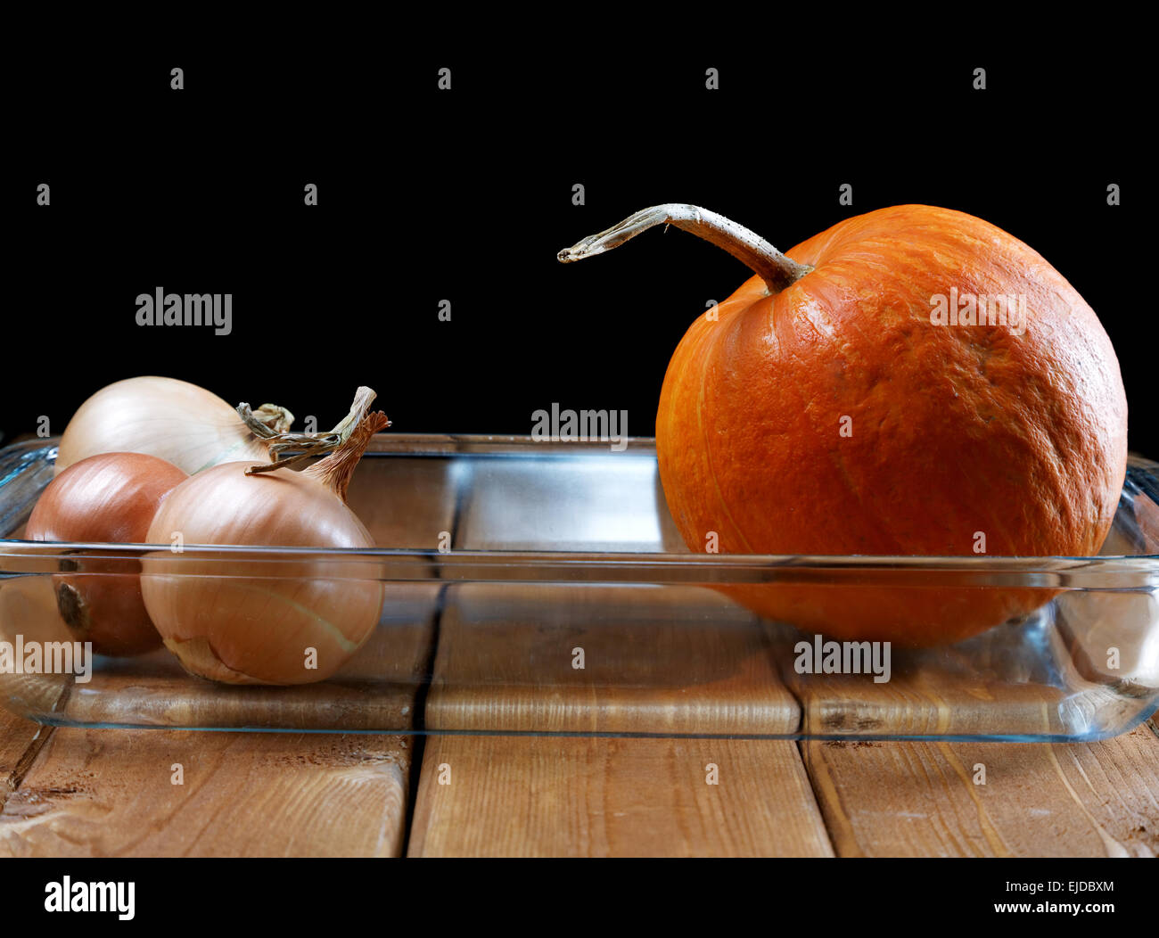 Small pumpkin and onions in a glass plate Stock Photo