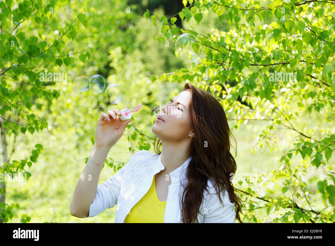 girl blow bubbles in spring forest Stock Photo