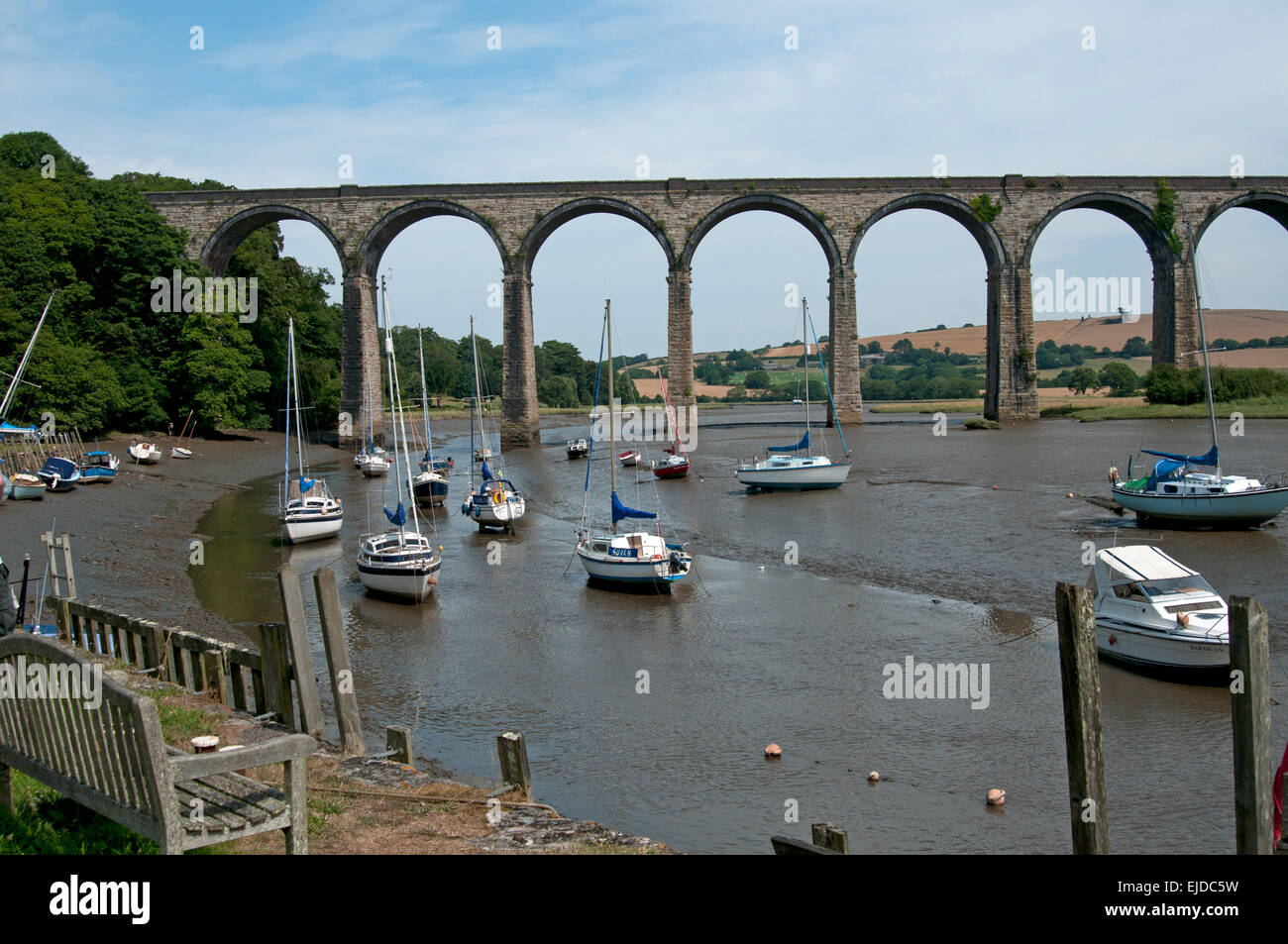 The viaduct at Port Eliot St Germans Cornwall UK with the river Tiddy tide out showing moored boats sitting in mud underneath the arches Stock Photo