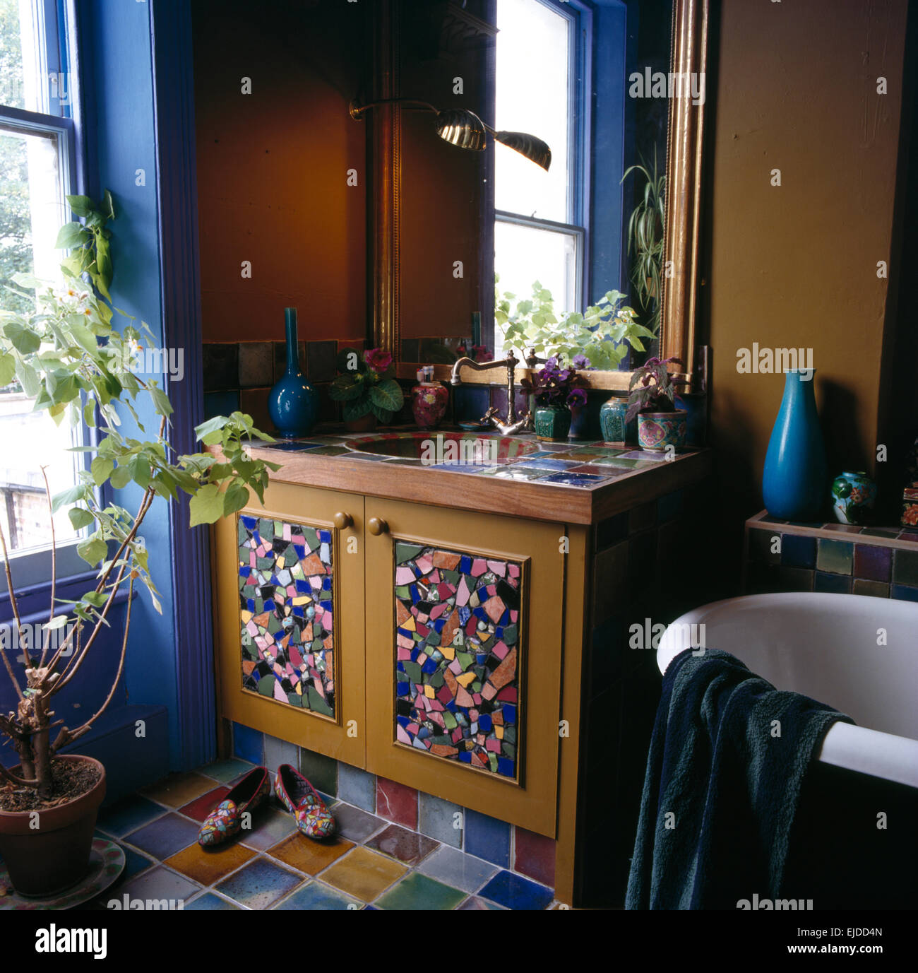 Sink in vanity unit with mosaic tiled panels on doors in bathroom Stock Photo Alamy