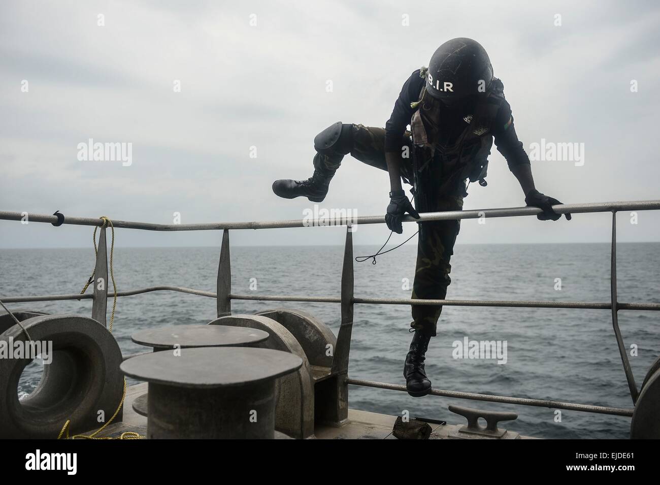 A Cameroonian Rapid Intervention Battalion special operations commando climbs over the rail of the Military Sealift Command's joint high-speed vessel USNS Spearhead during a visit, board, search and seizure drill  as part of Obangame Express March 22, 2015 in the Gulf of Guinea. Stock Photo