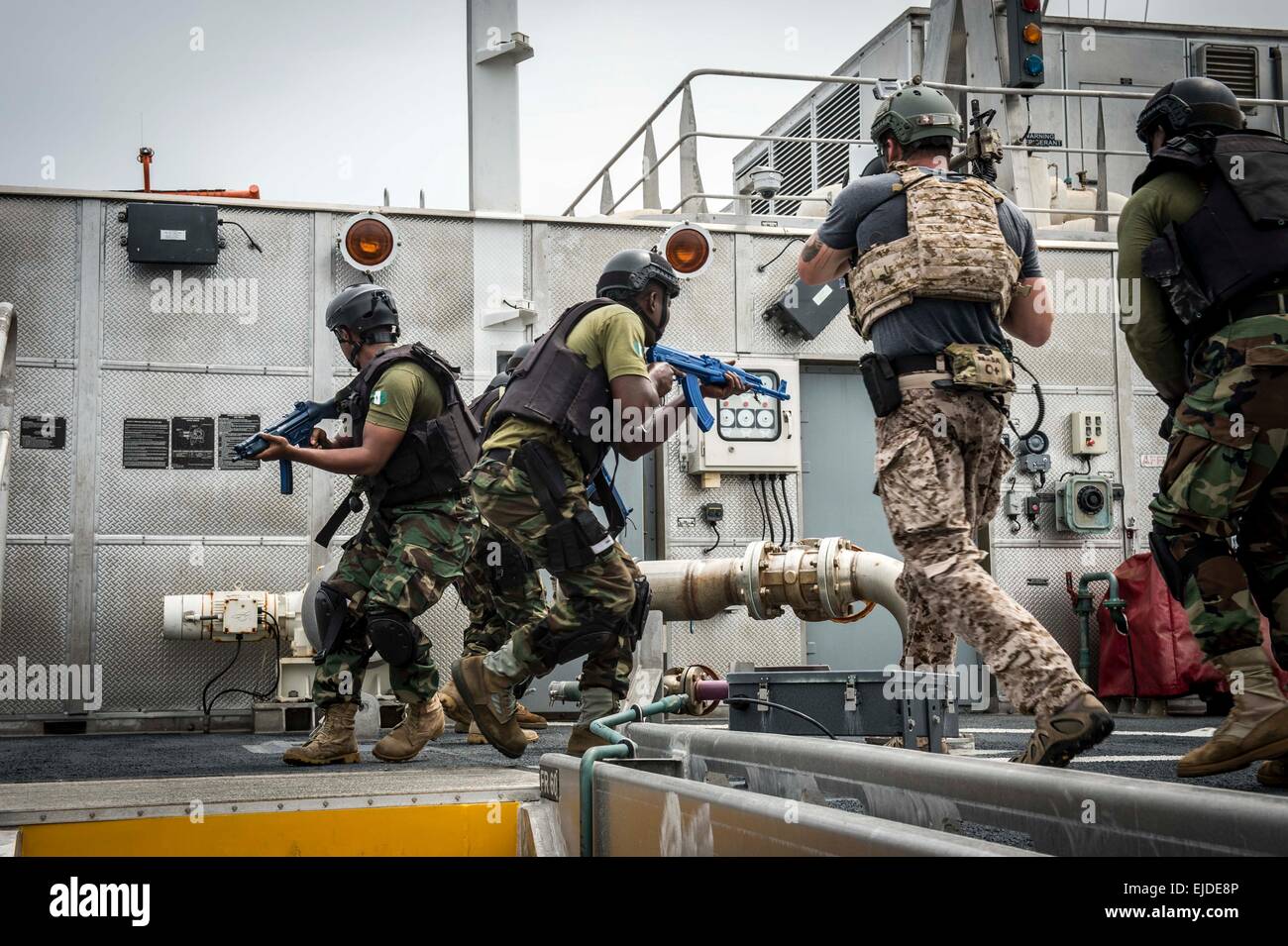 Nigerian military special operations commandos and U.S Navy Seal team members take part in a visit, board, search and seizure drill aboard the Military Sealift Command's joint high-speed vessel USNS Spearhead as part of Obangame Express March 20, 2015 in the Gulf of Guinea. Stock Photo