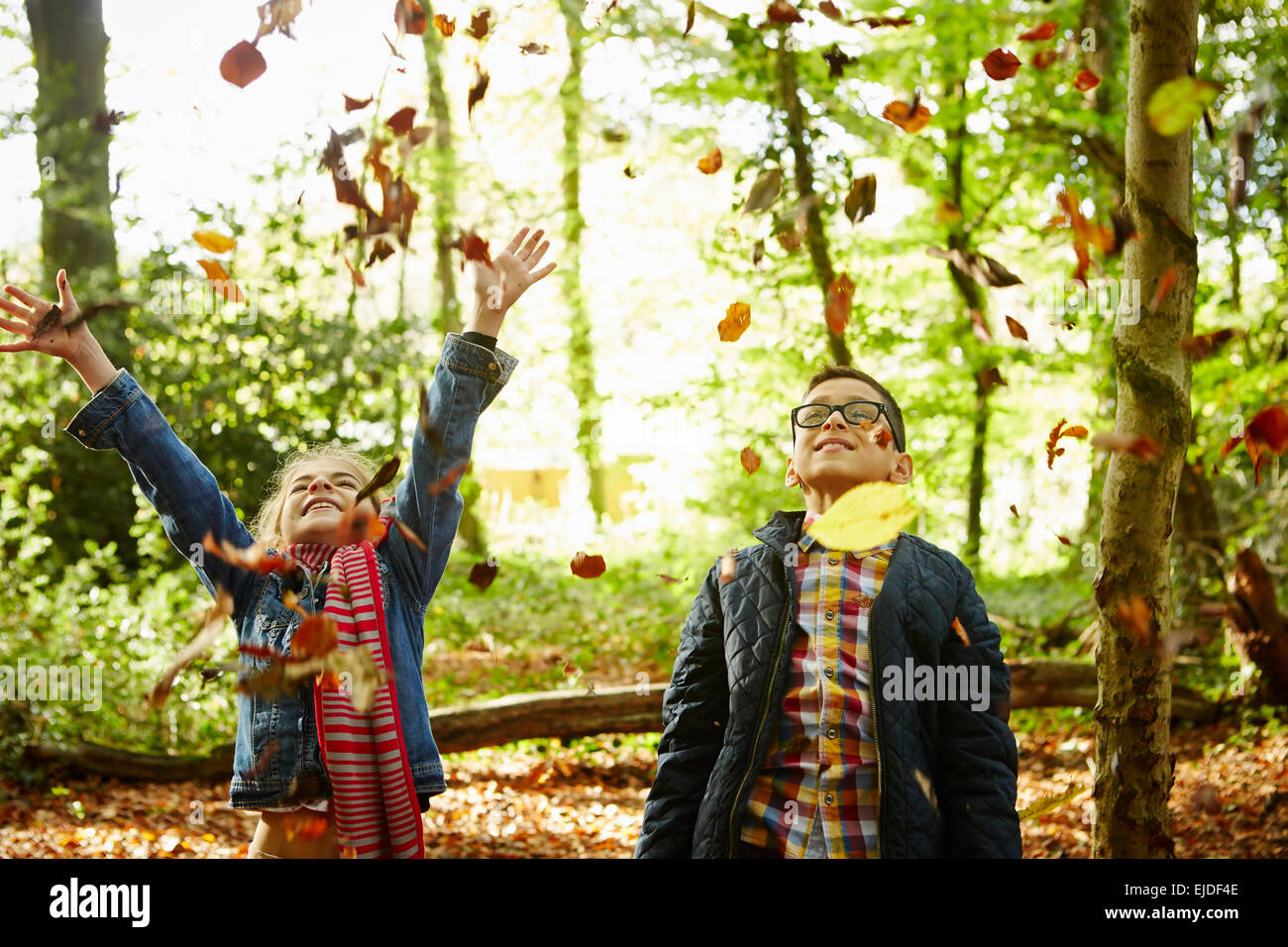 A girl and her brother throwing autumn leaves in the air Stock Photo ...