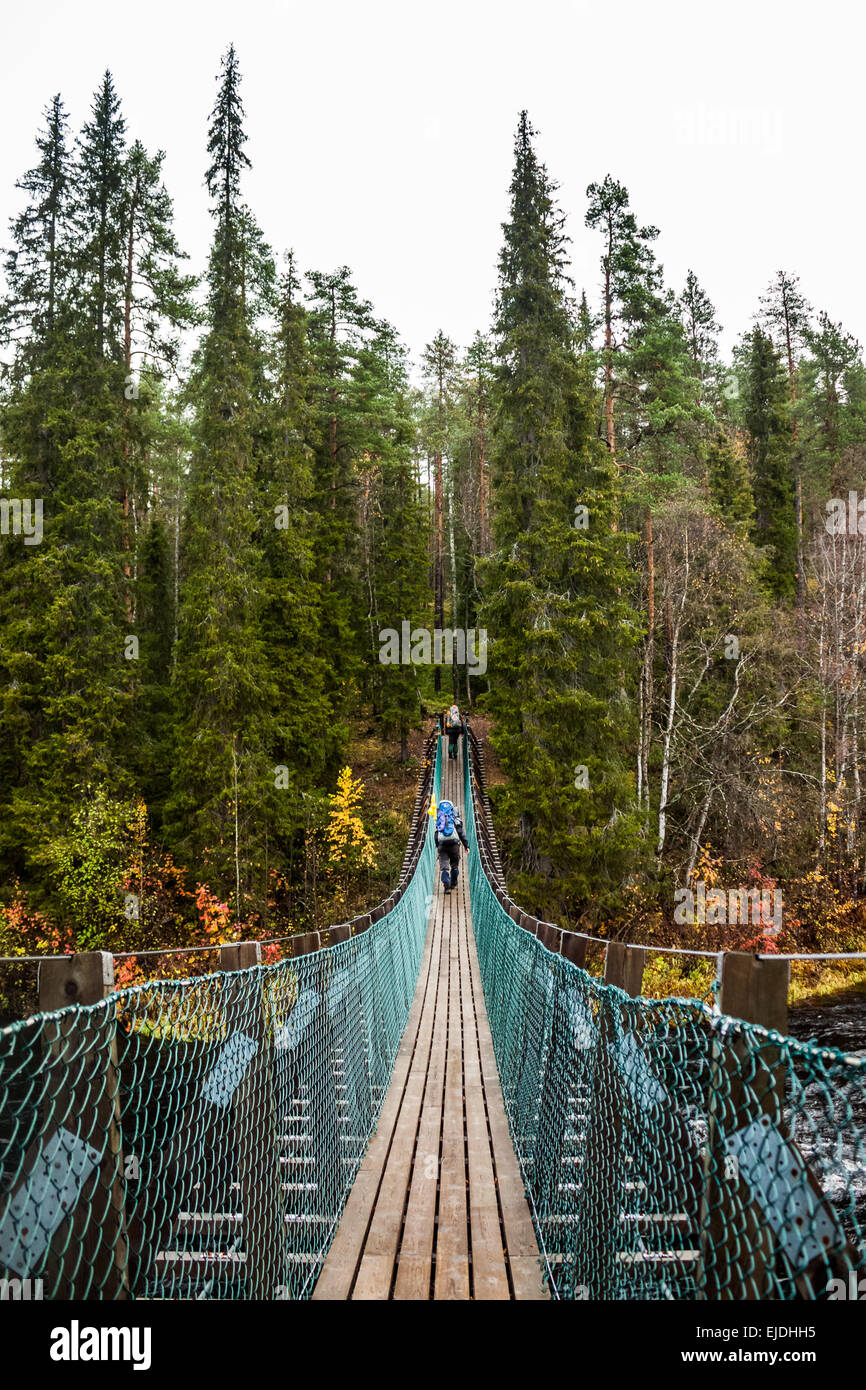 Two hikers crossing a suspension bridge Stock Photo - Alamy