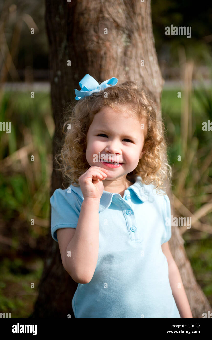 Young girl leaning against oak tree, portrait Stock Photo