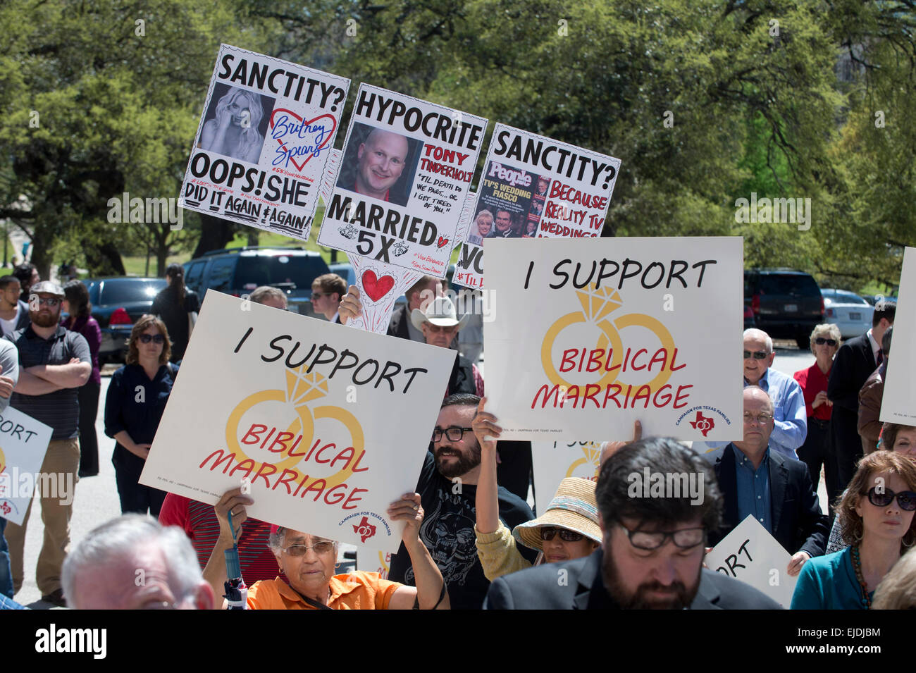 A counter-protester holds a sign mocking the sanctity of marriage at a rally opposing gay marriage at Texas Capitol in Austin Stock Photo