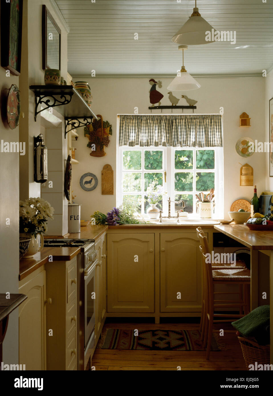 Gingham pelmet on window in nineties cottage kitchen Stock Photo