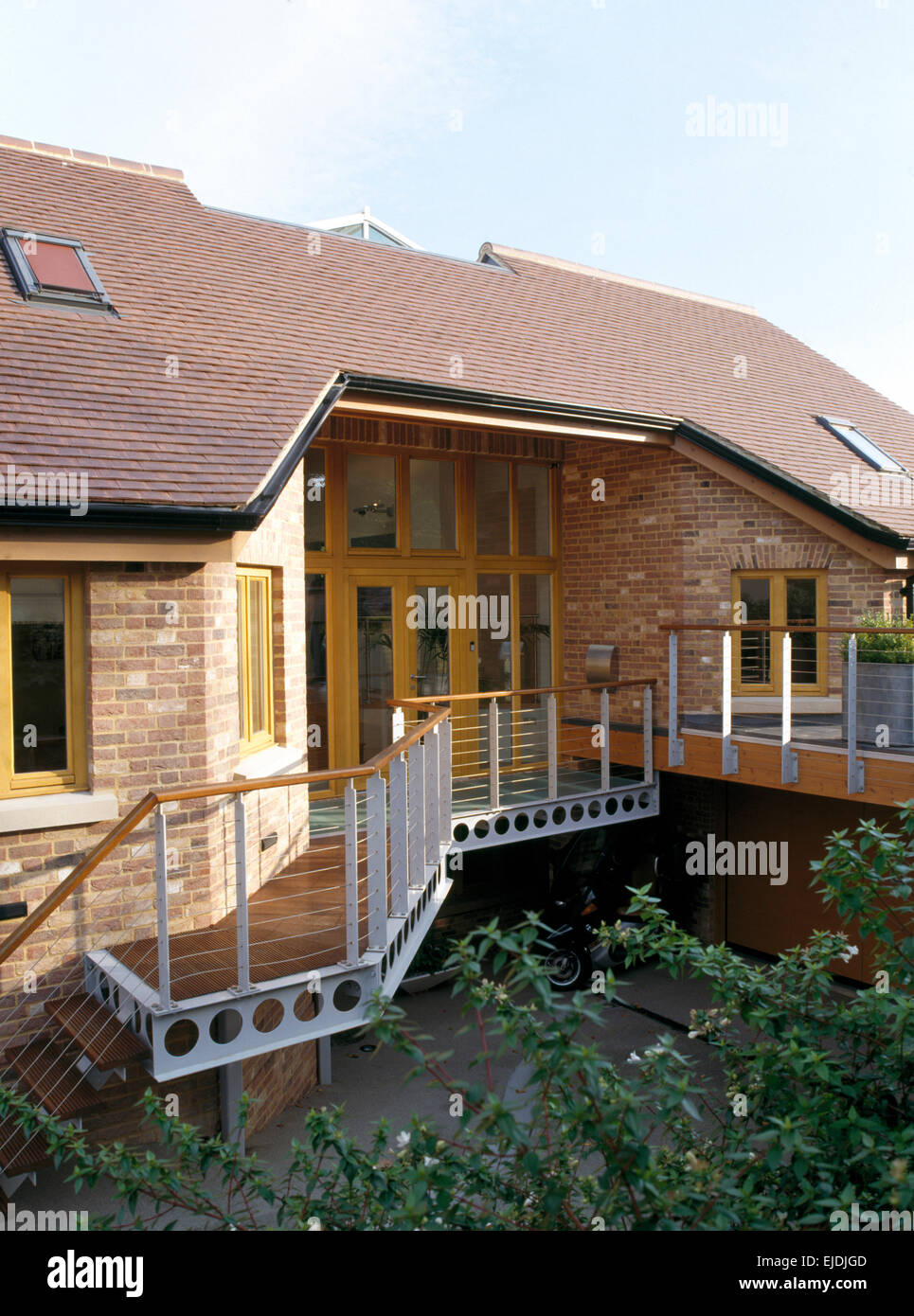 Exterior of single storey new build house with metal banisters on walkway Stock Photo