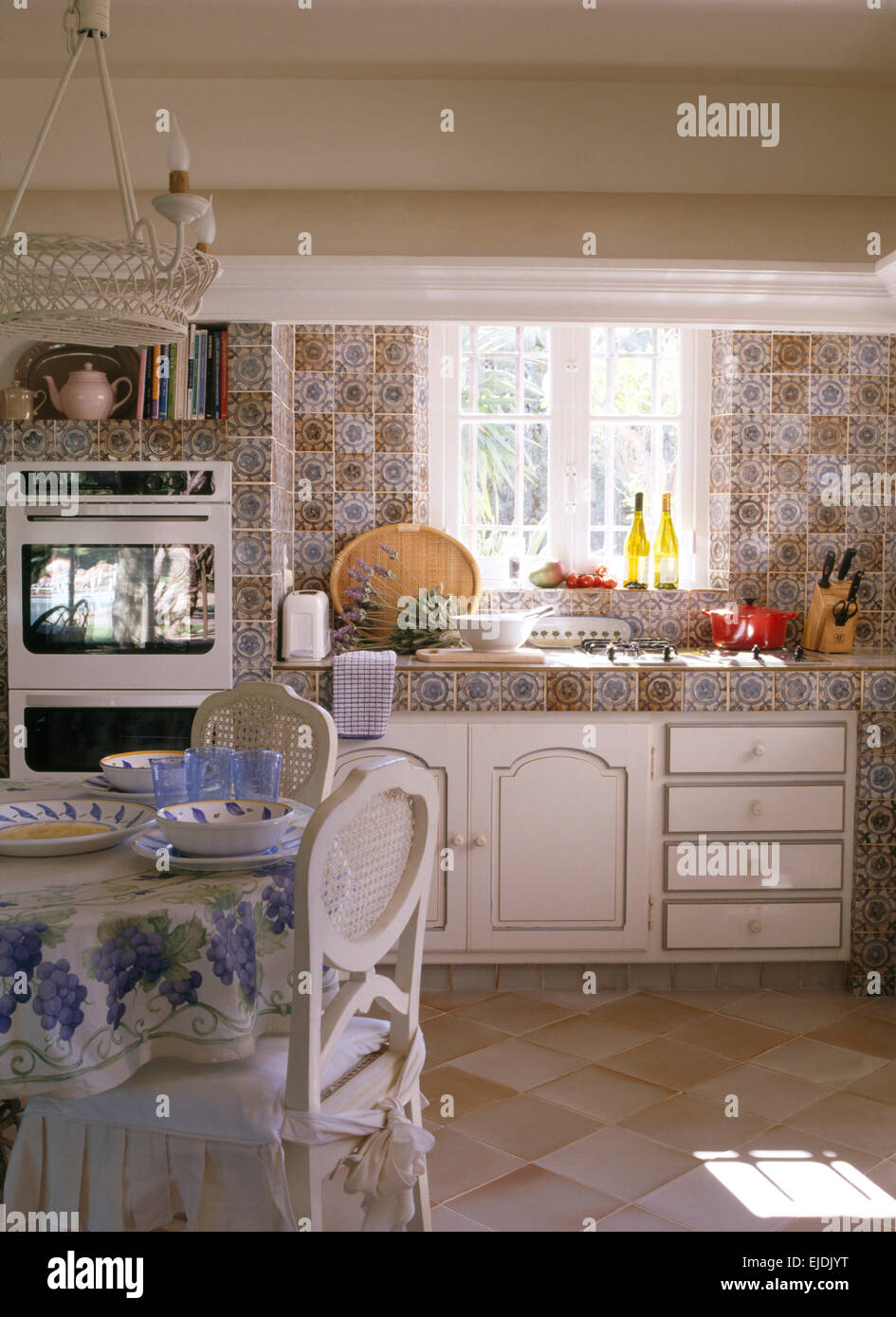 https://c8.alamy.com/comp/EJDJYT/patterned-wall-tiles-and-worktop-in-french-country-kitchen-with-white-EJDJYT.jpg