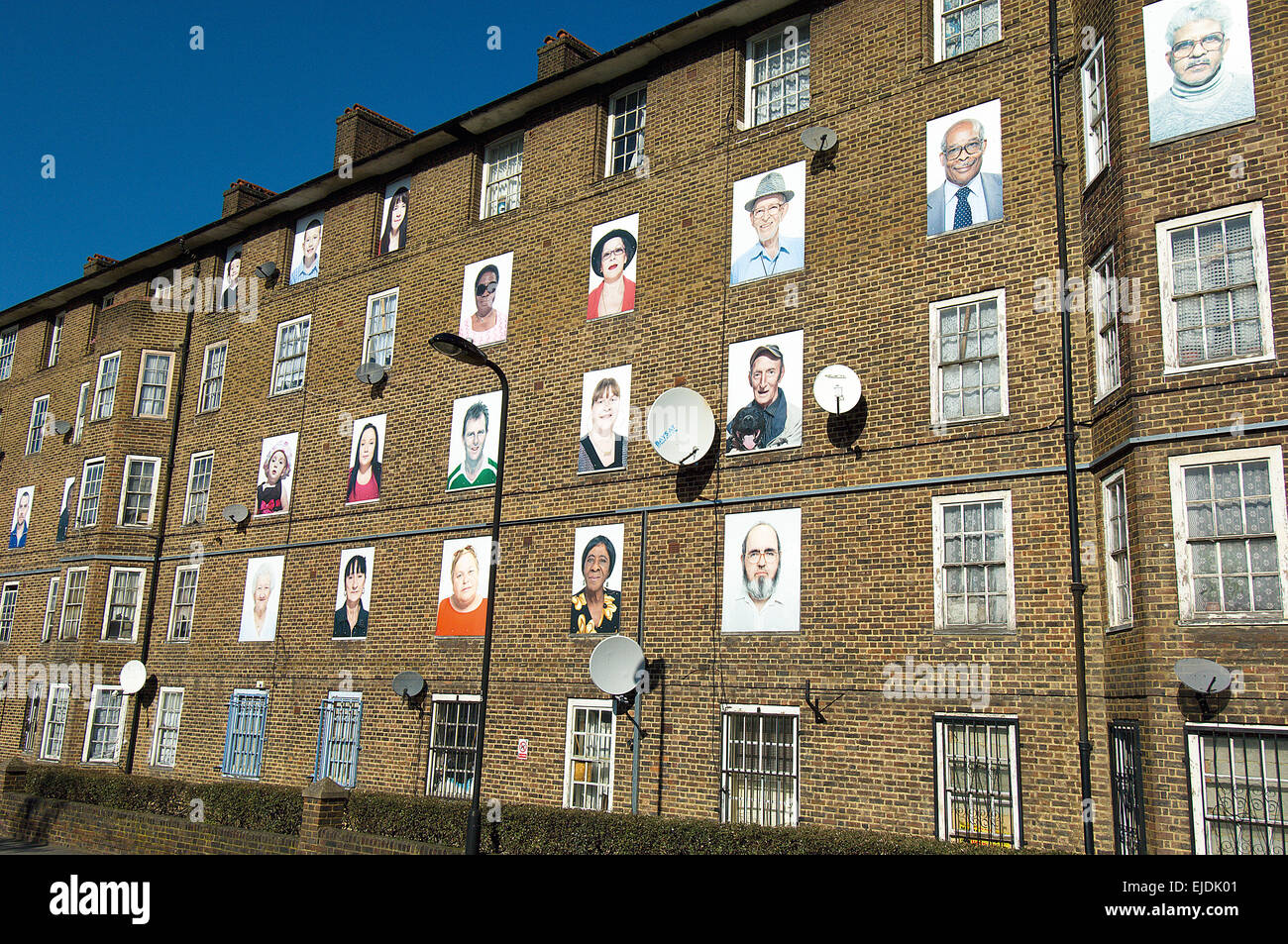 Hacney's I Am Here project at Haggerston and Kingsland Estate involve artists putting portraits of residents on the windows. Stock Photo