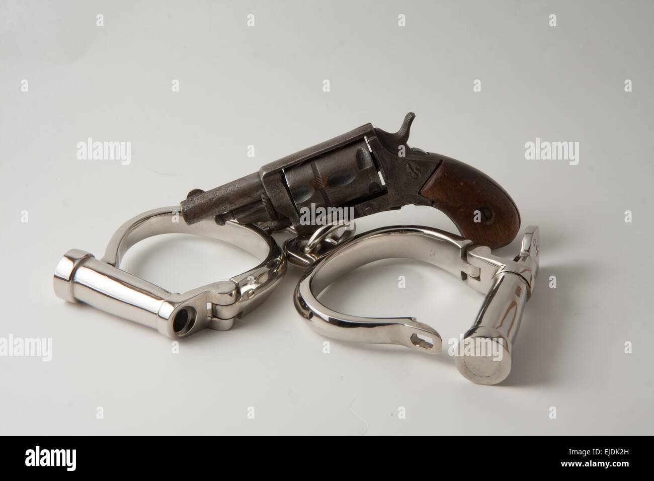 old handcuffs with locking screw English style and revolver derringer Stock Photo