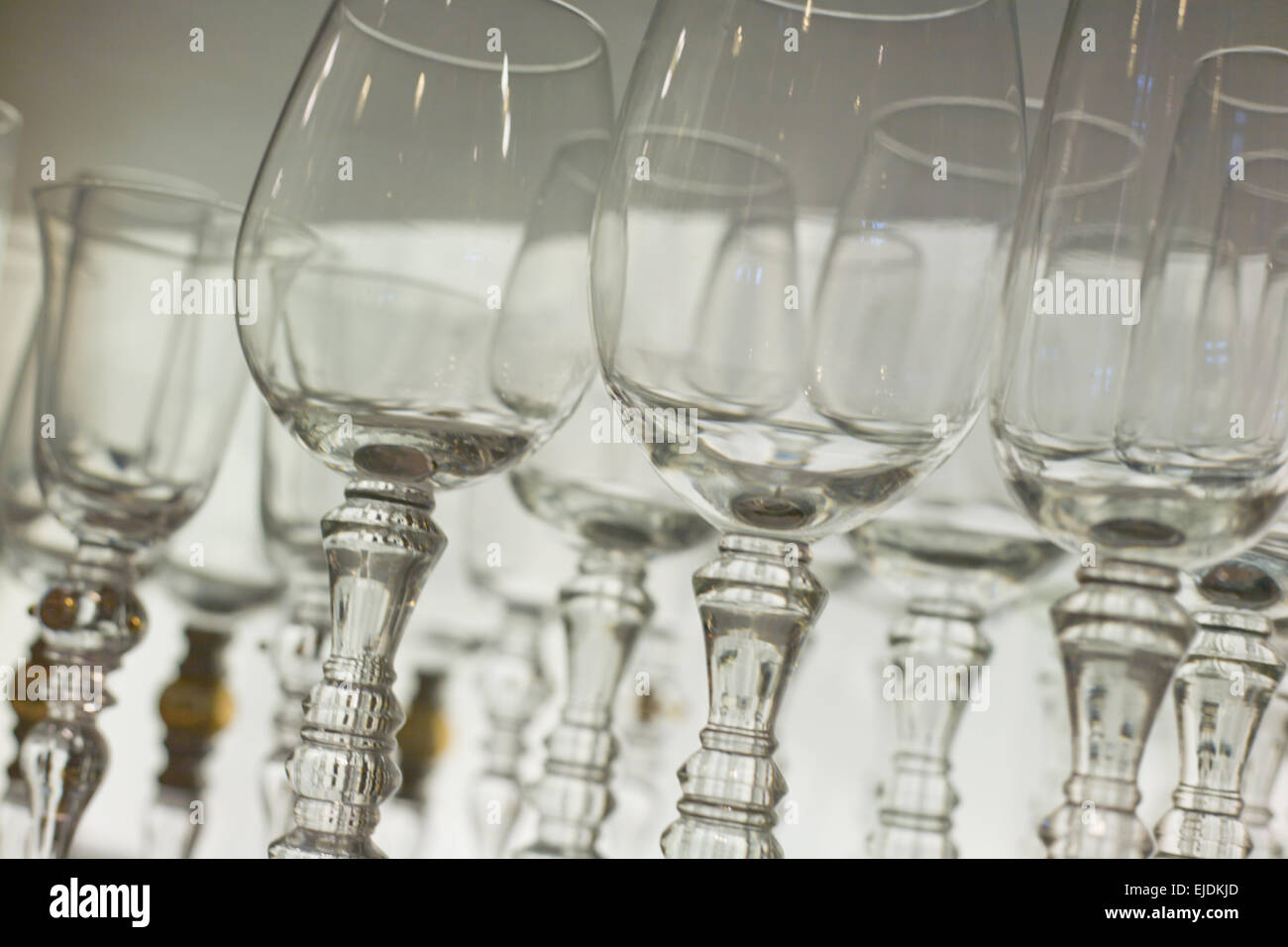 Some rows of empty wine glasses over white background. Closeup Stock Photo