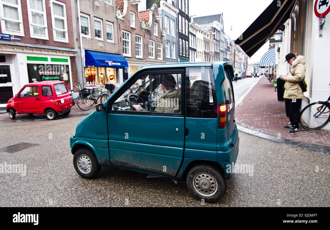 Tiny blue micro-car called a Canta on the streets of Amsterdam. No driving license is required for these vehicles. Stock Photo