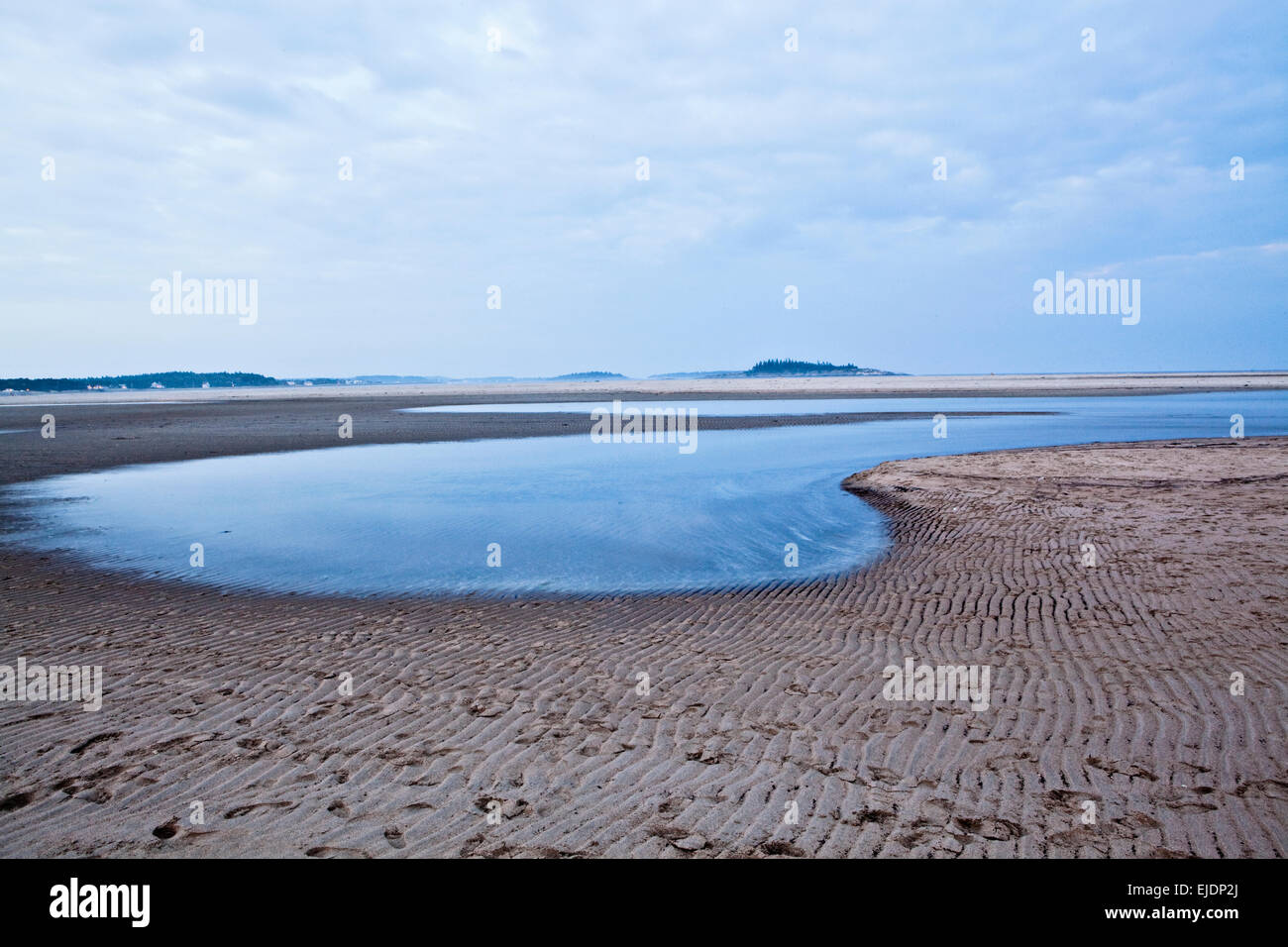 The tide slowly creeps up the shoreline of Popham Beach, Maine Stock