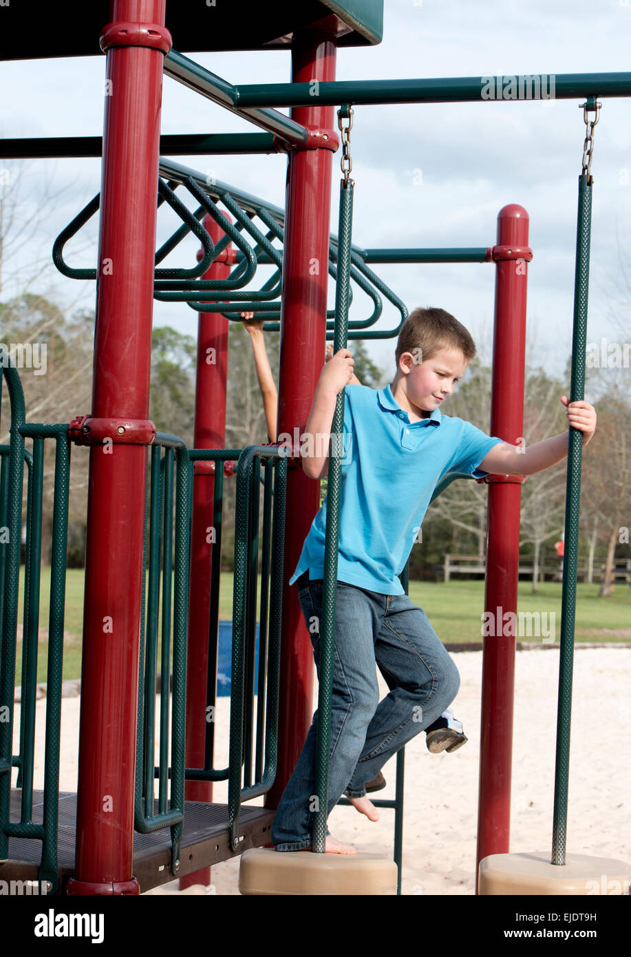 Eight year old boy playing on a park playground Stock Photo