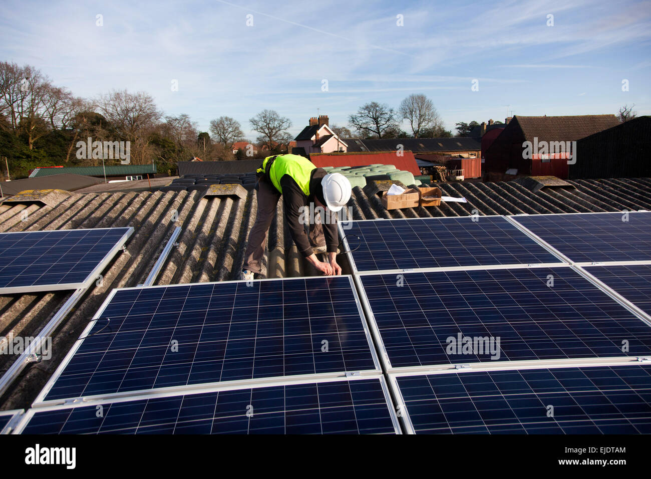 Jake Beautyman installs solar panels on a barn roof on Grange farm