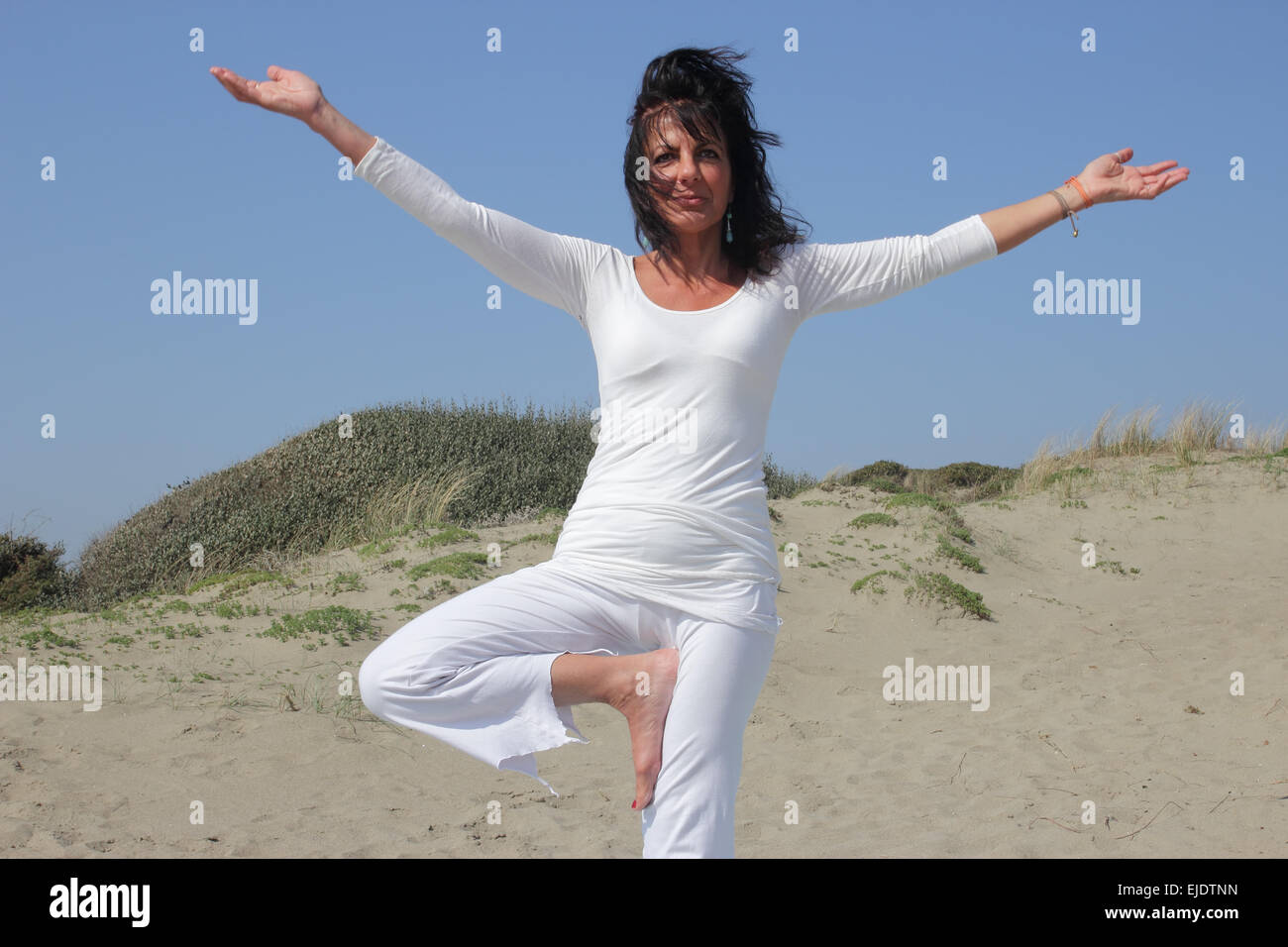 woman practicing vrksasana yoga posture Stock Photo