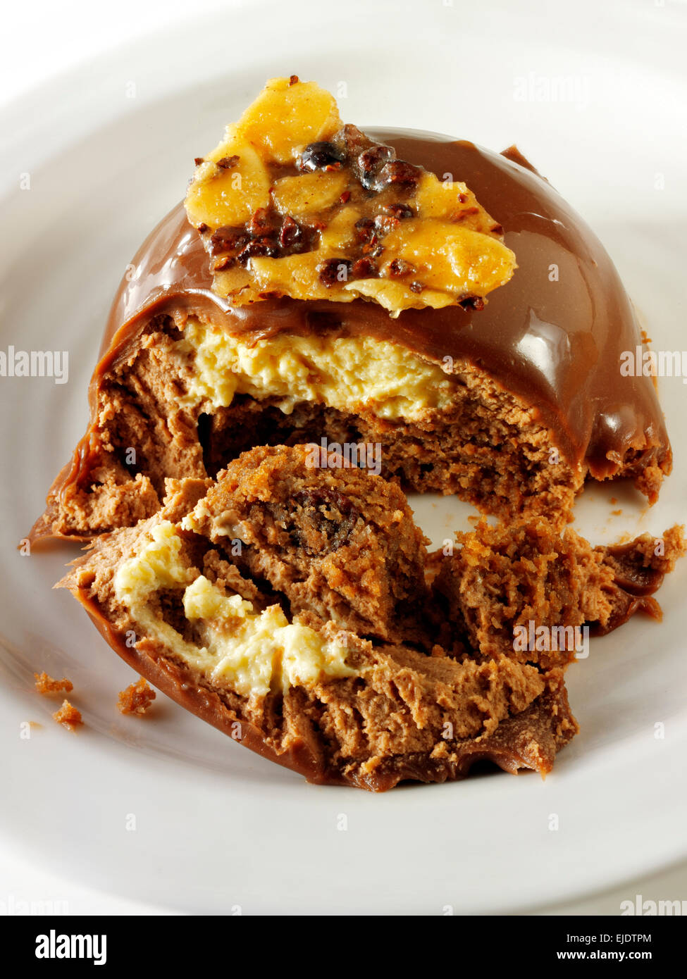Cake with a pattered chocolate case and piped chestnut puree with cumquat sauce, in a modern designer dish Stock Photo