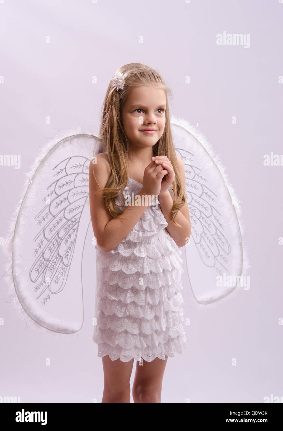 Six year old girl in a bright angel costume with wings on a white background Stock Photo