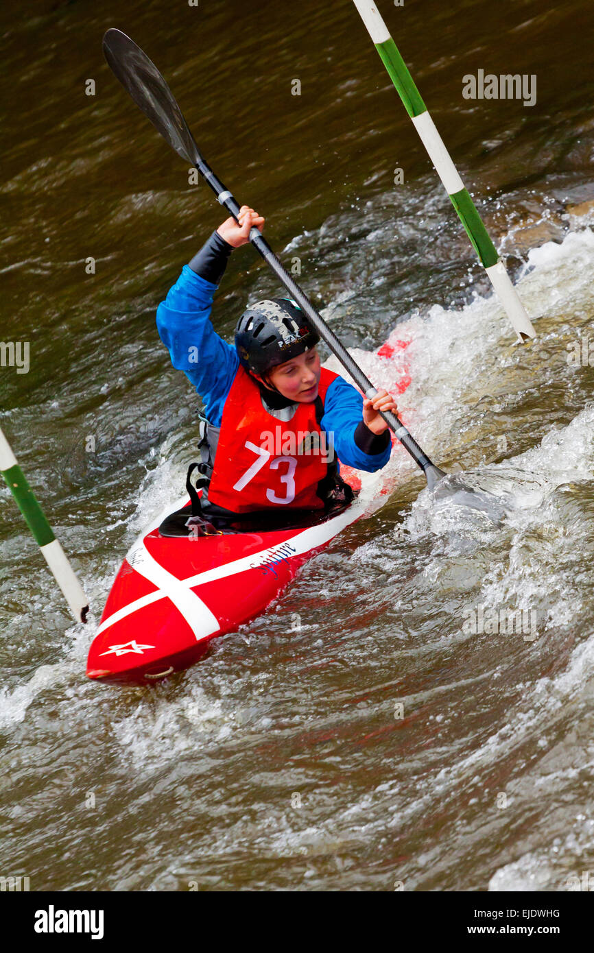 Female Competitor in a canoe slalom race at Matlock Bath on the River Derwent in the Derbyshire Dales Peak District England UK Stock Photo