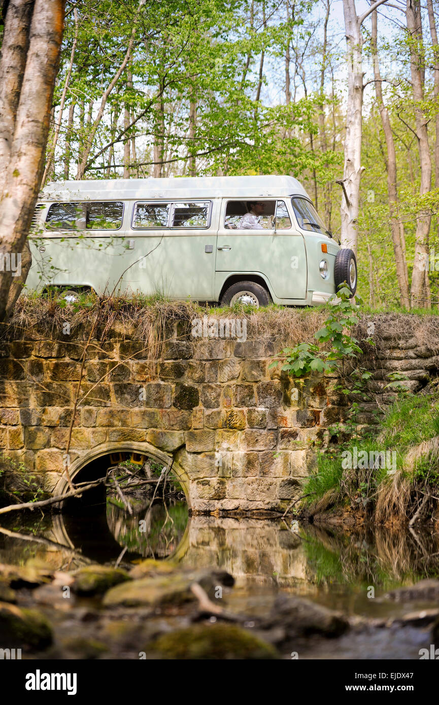 Volkswagen Camper crossing a bridge over a stream on the Ashdown Forest in East Sussex UK. Stock Photo