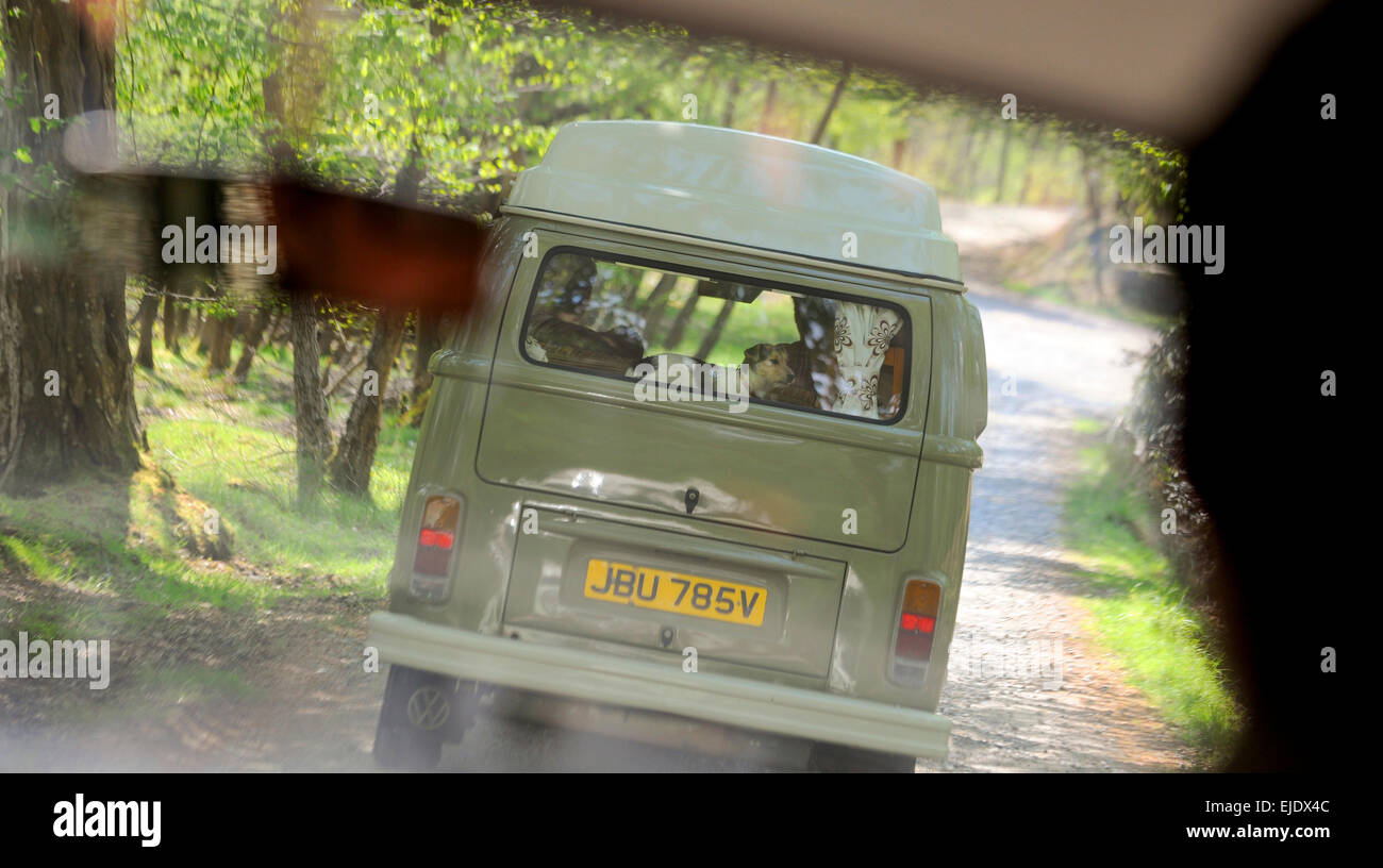 A Volkswagen Camper bus on a country lane in East Sussex viewed from the inside of a second camper bus. Stock Photo
