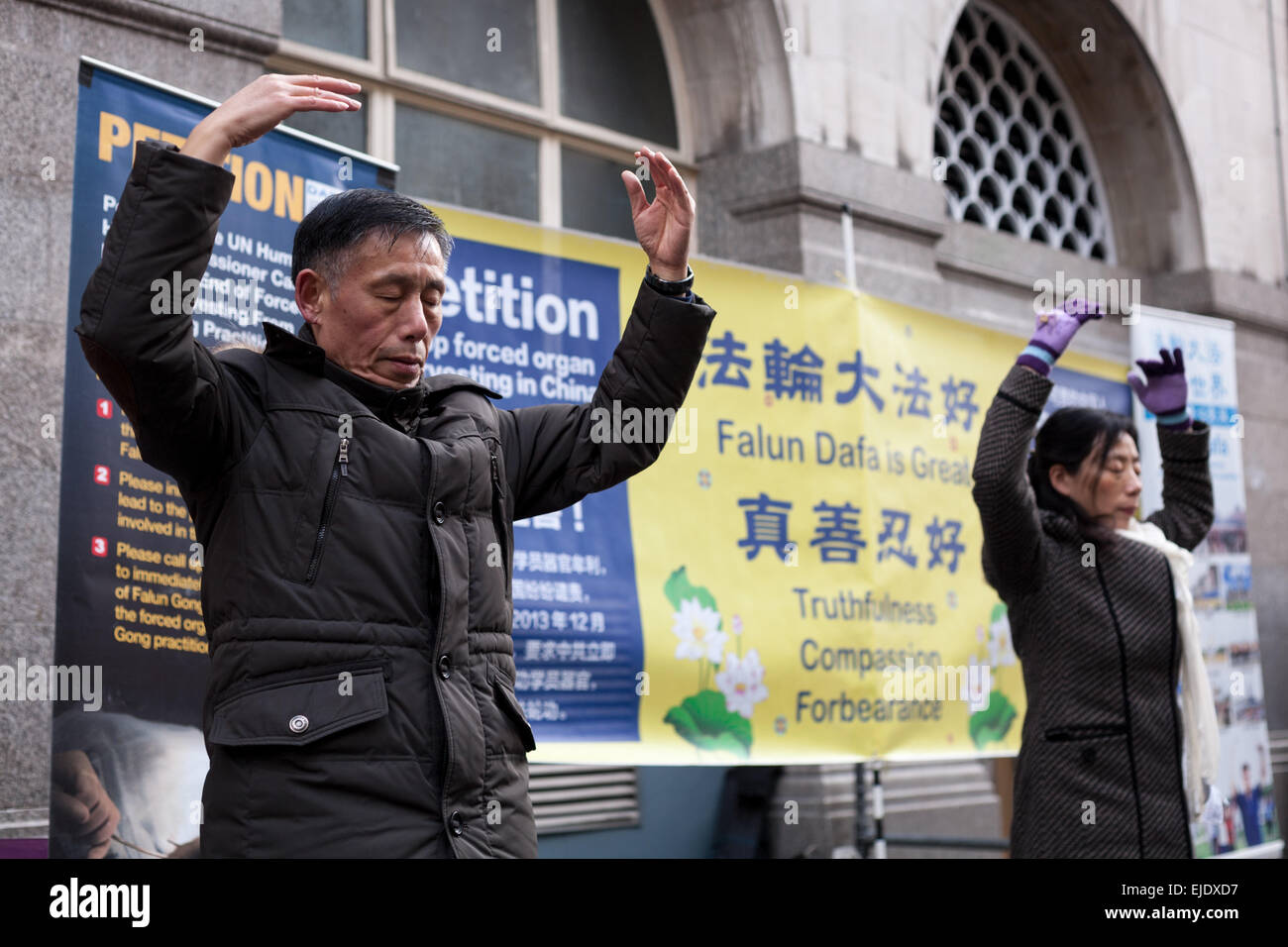 A man and woman practice Chinese spiritual discipline Falun Dafa (Falun Gong) in Chinatown in central London Stock Photo