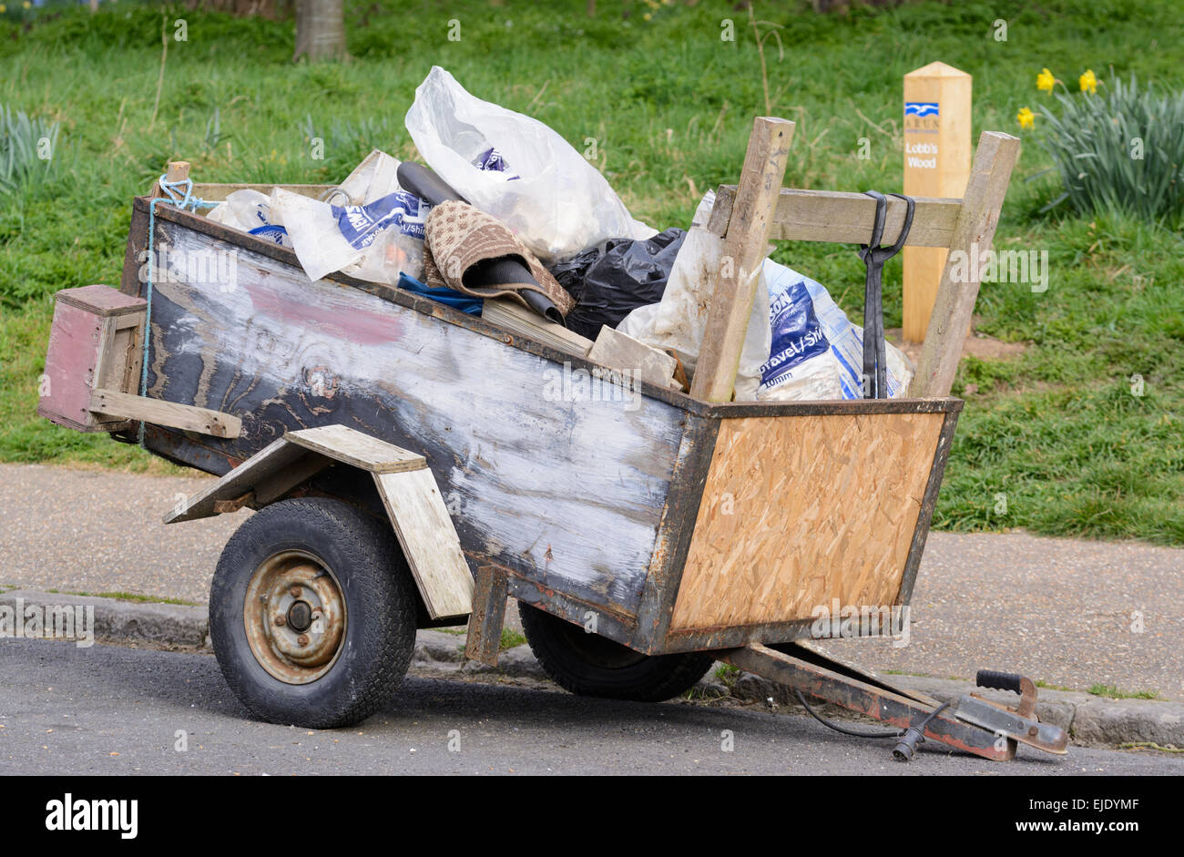Small trailer full of rubbish parked by the roadside. Stock Photo