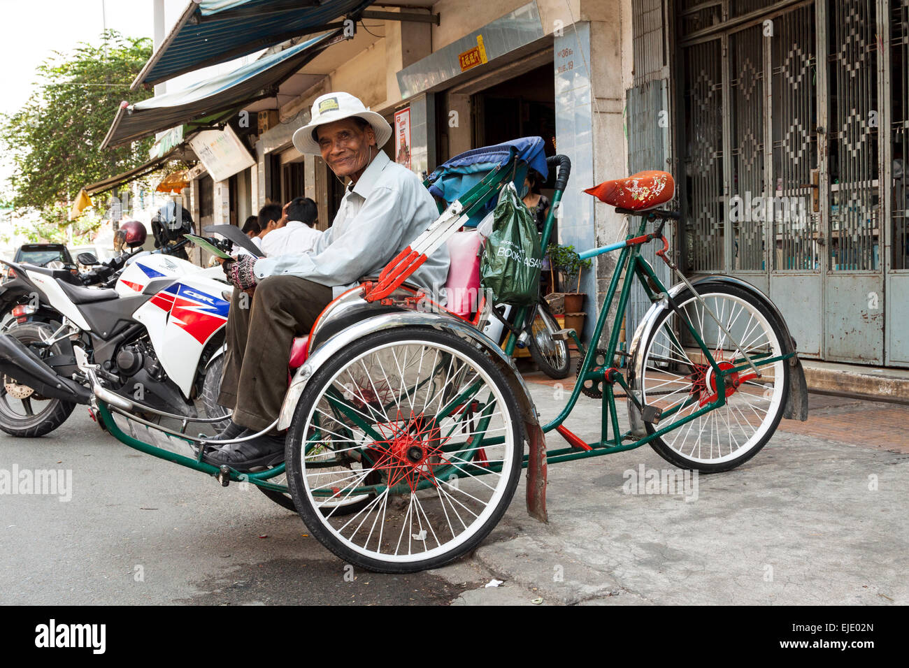 Rickshaw man waiting for customers in Phnom Penh, Cambodia, Asia. Stock Photo