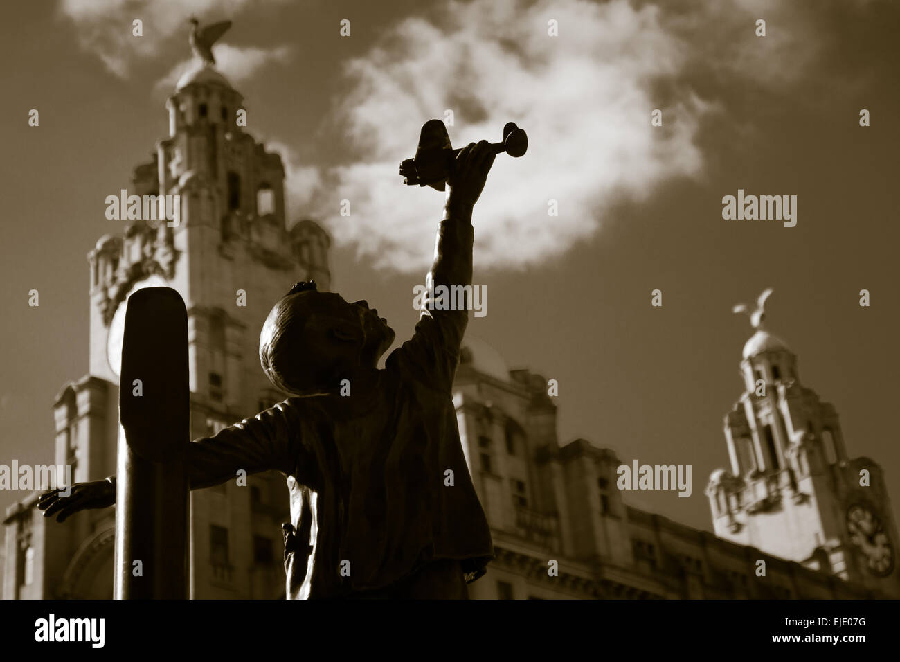 Statue of a boy playing with this toy aircraft. Stock Photo