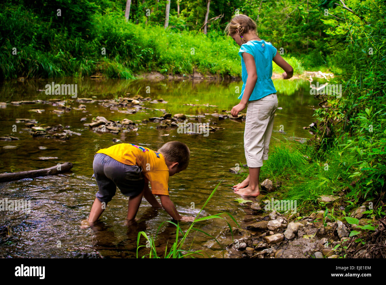 A boy and girl play in the Four Mile Creek in Oxford Oh Stock Photo