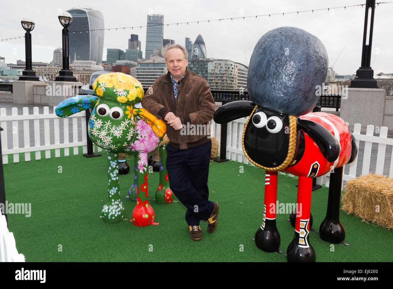 London, UK. 24 March 2015. Animator Nick Park poses with sheep 'Petal' designed by Emily Ketteringham and the 'Yeoman of the Baaard' sheep designed by Vivi Cuevas at the Shaun in the City London launch. Aardman Animations' 'Shaun the Sheep' are set to be dotted around London from Saturday 28th March to form a special arts trail that will benefit thousands of children in hospitals around the UK. The sculptures have been designed by high profile artists, designers and celebrities including David Gandy, Zayn Malik, Zandra Rhodes and Cath Kidston and will be auctioned after the exhibition finishes Stock Photo