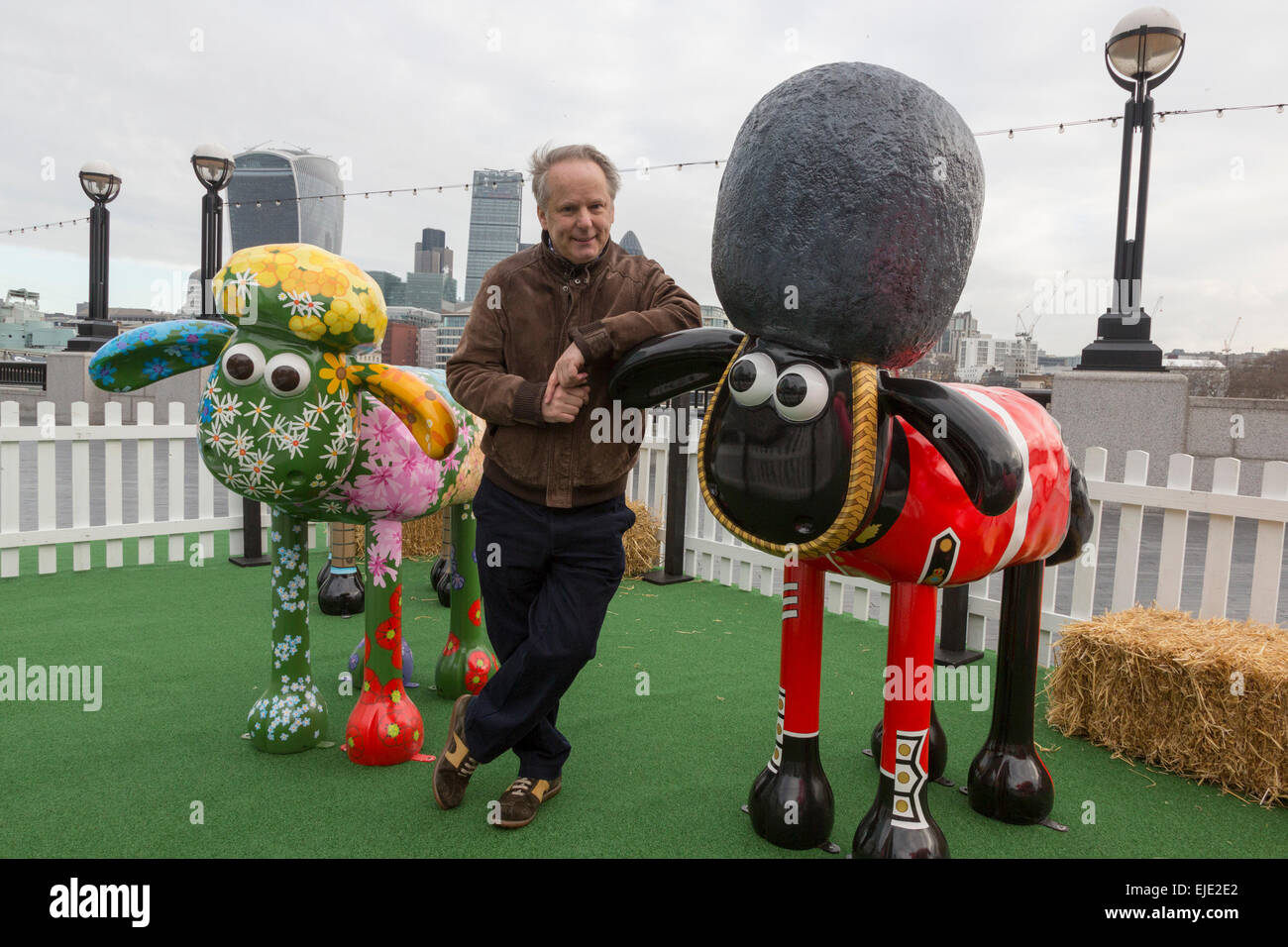 London, UK. 24 March 2015. Animator Nick Park poses with sheep 'Petal' designed by Emily Ketteringham and the 'Yeoman of the Baaard' sheep designed by Vivi Cuevas at the Shaun in the City London launch. Aardman Animations' 'Shaun the Sheep' are set to be dotted around London from Saturday 28th March to form a special arts trail that will benefit thousands of children in hospitals around the UK. The sculptures have been designed by high profile artists, designers and celebrities including David Gandy, Zayn Malik, Zandra Rhodes and Cath Kidston and will be auctioned after the exhibition finishes Stock Photo