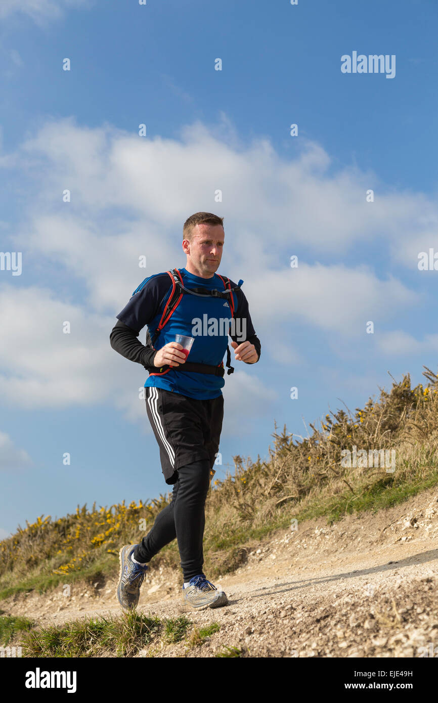 A runner in an endurance race starting  from Lulworth Cove and continuing along the South West Path. Stock Photo