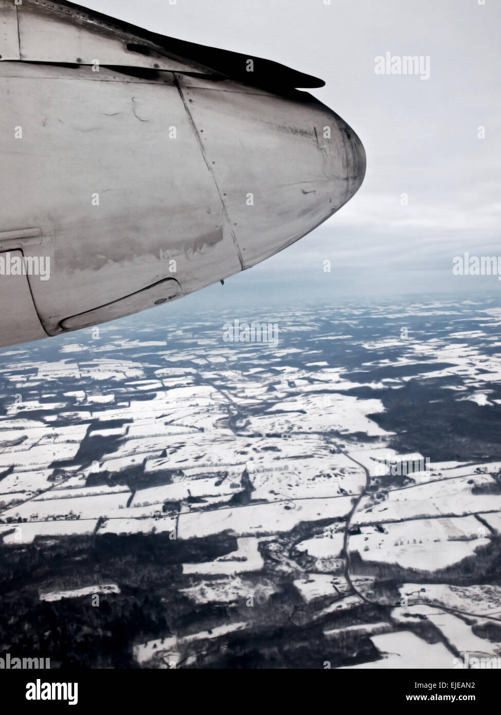 view of the landing gear and wheel well of a Bombardier aircraft over winter landscape Stock Photo