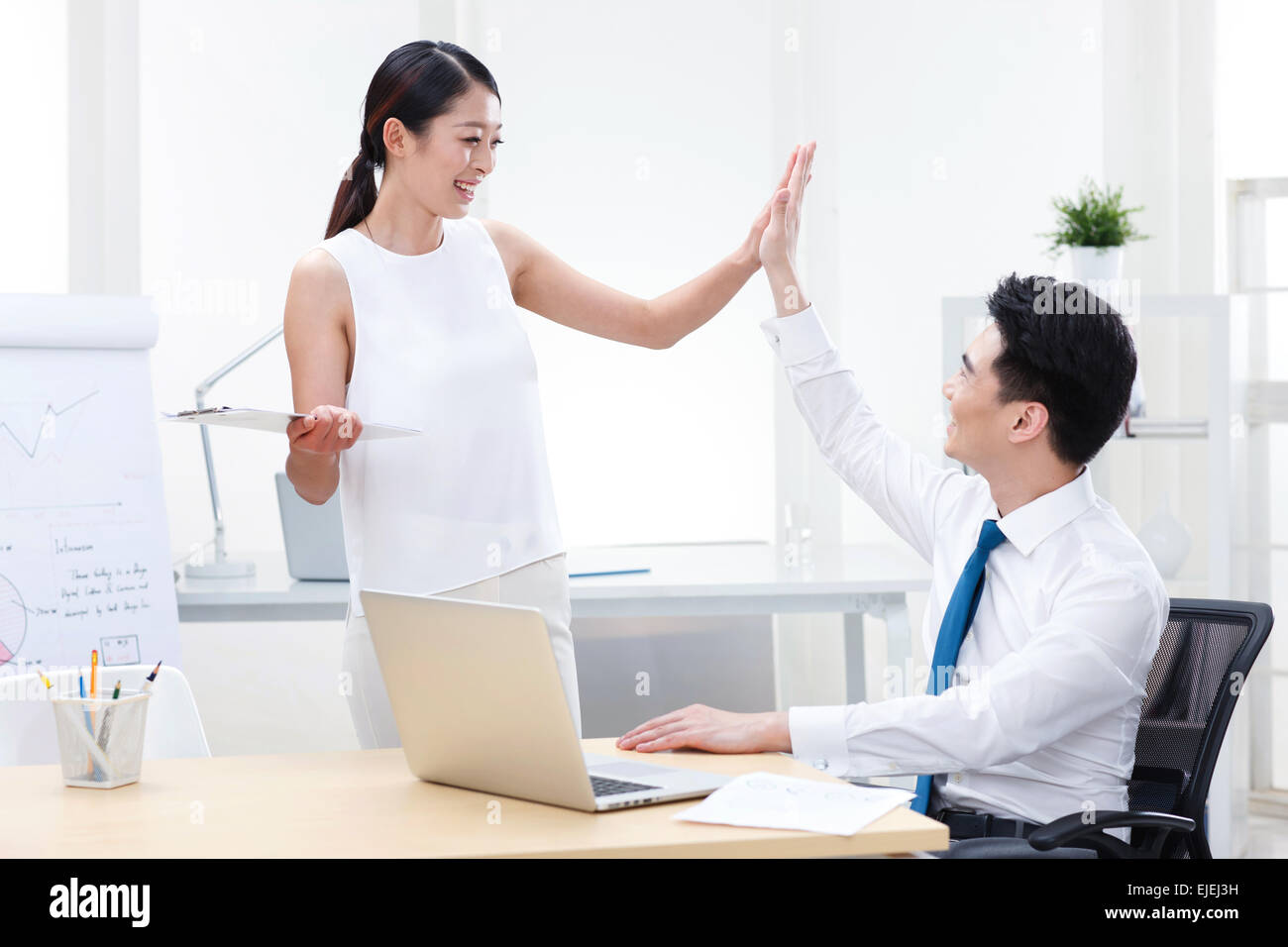 The young business people in office high fives Stock Photo