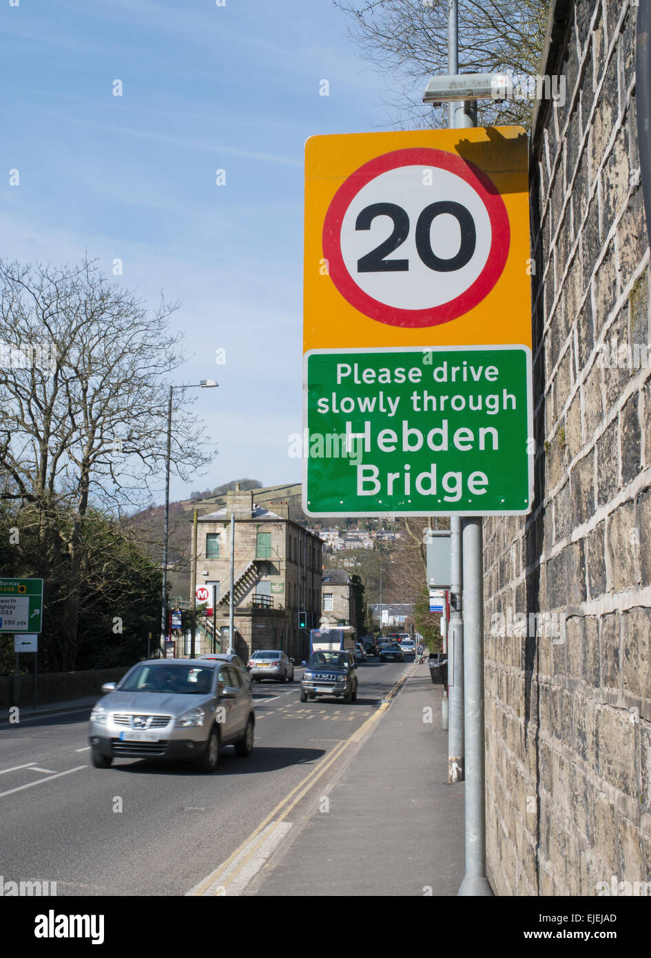 20 mph speed restriction sign with speeding  car, Hebden Bridge, West Yorkshire, England, UK Stock Photo