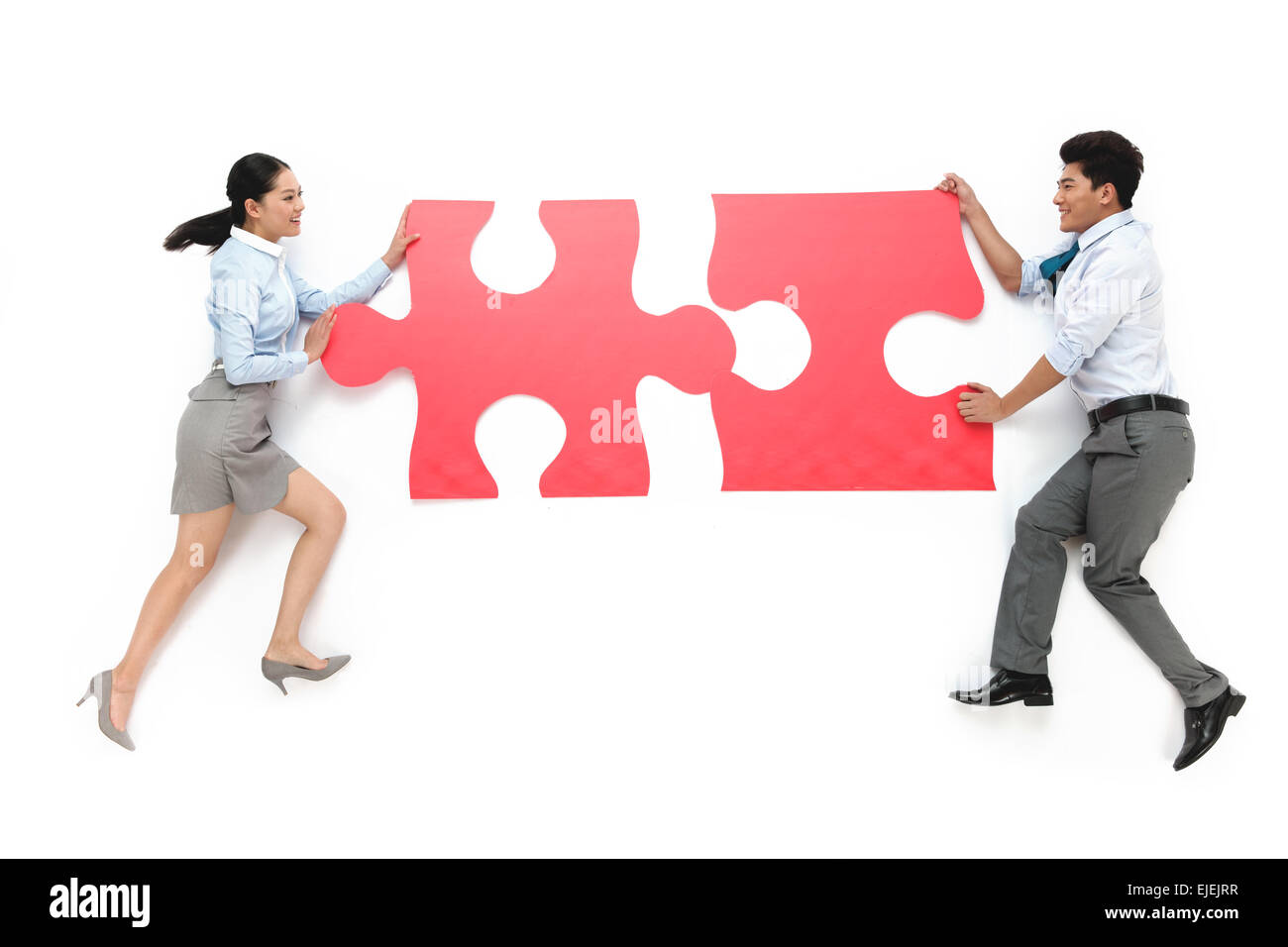Business men and women carrying puzzle pieces Stock Photo