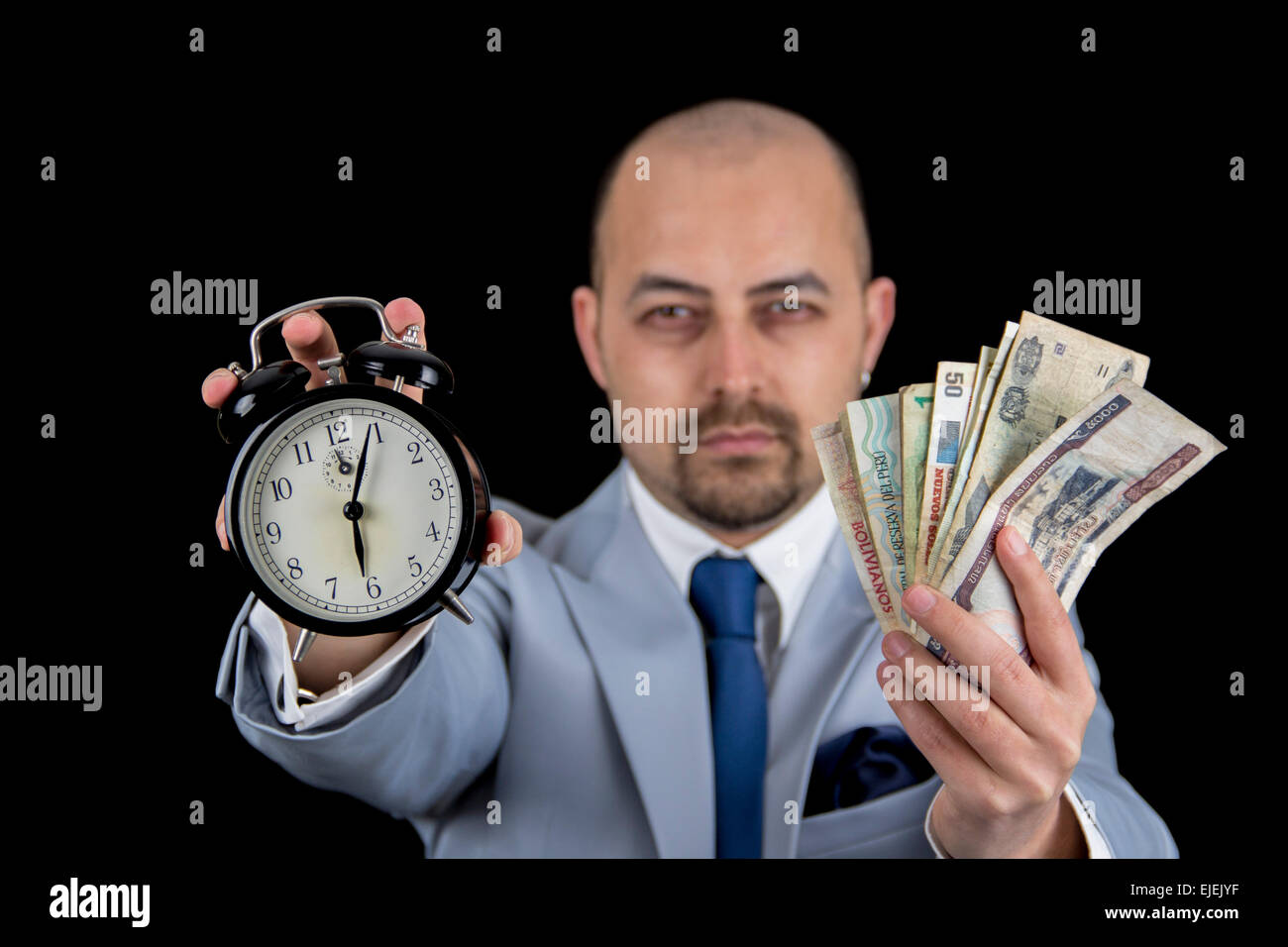 man holding money and alarm wearing a business suit, race against the clock, deadline Stock Photo