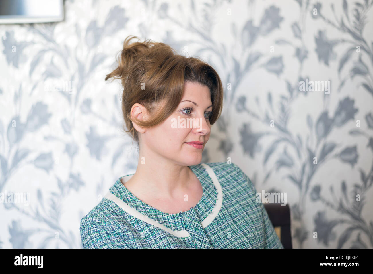 Portrait of woman sitting in living room Stock Photo - Alamy