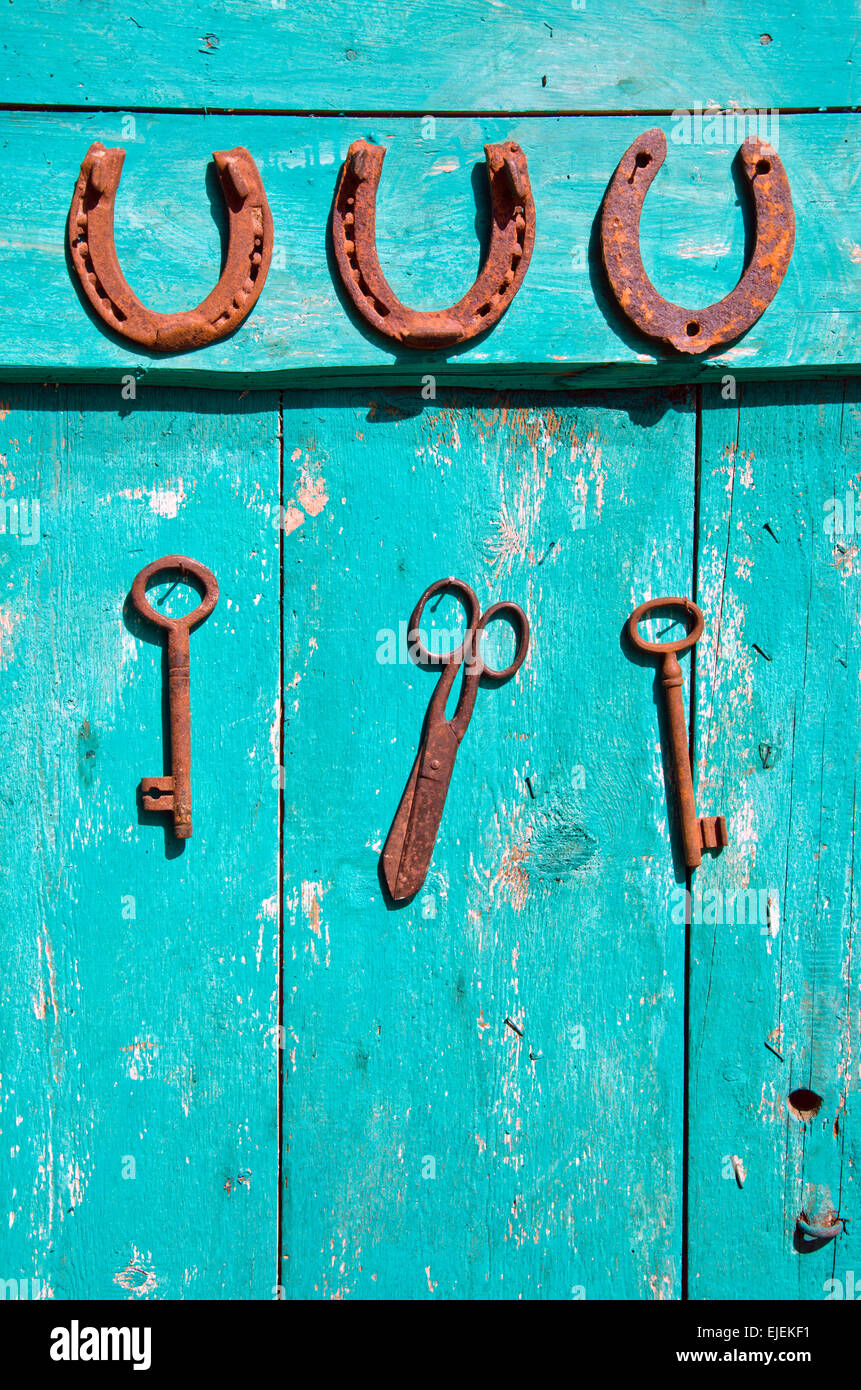 old rusty historical key and luck symbol horseshoe on wooden green farm ...