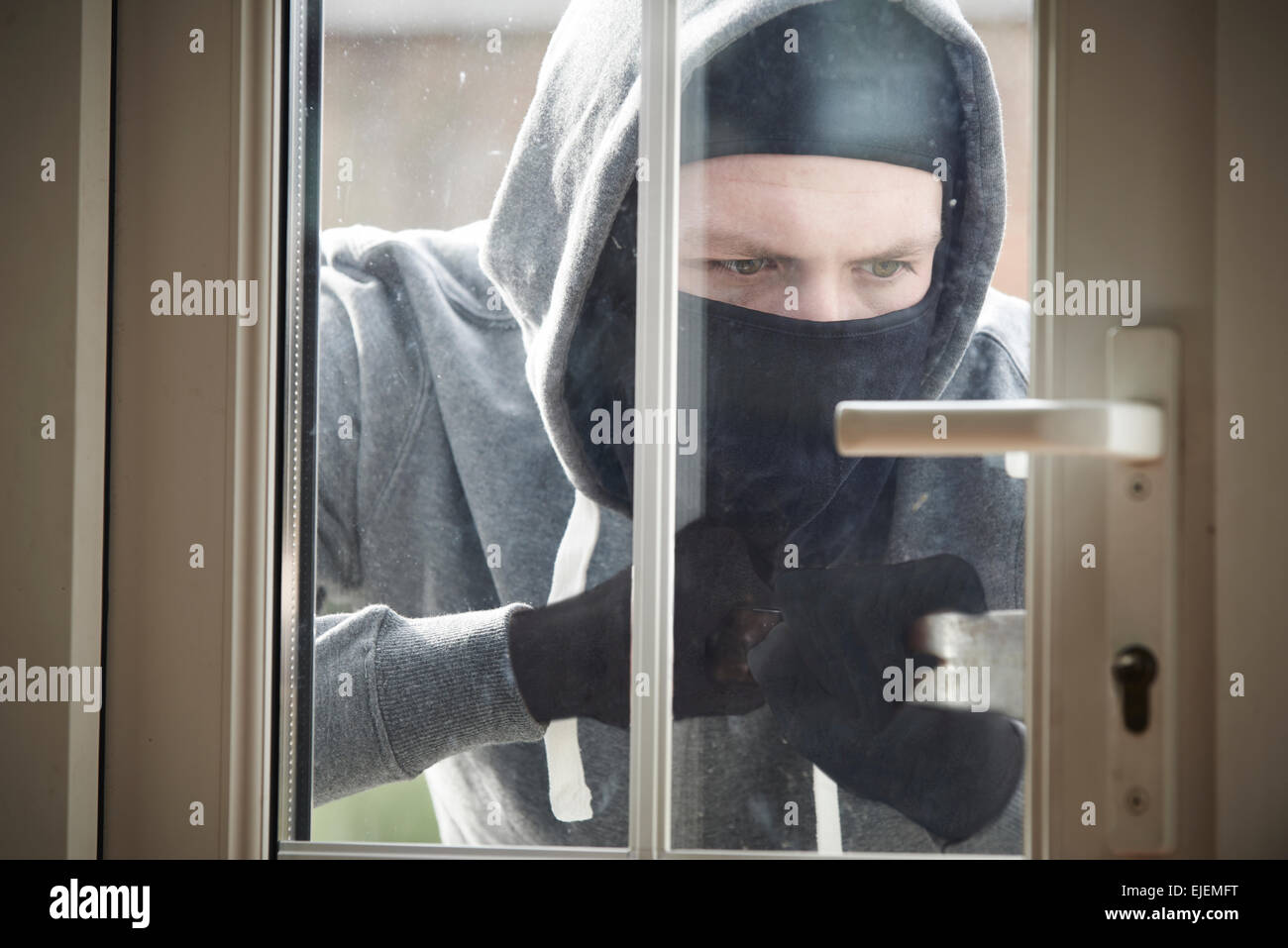 Burglar Breaking Into House By Forcing Door With Crowbar Stock Photo