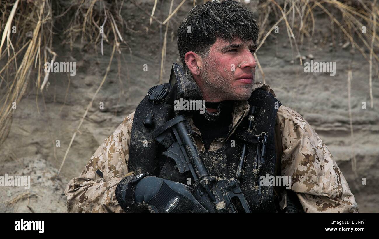 A US Marine reconnaissance scout swimmer covered in sand after coming ashore during an amphibious beach exercise at Onslow beach March 20, 2015 in Camp Lejeune, N.C. Scout swimmers are dropped off about 500 meters away from the shore, where they swim in and secure a landing zone, and signal the boat teams to land on shore at the same time. Stock Photo
