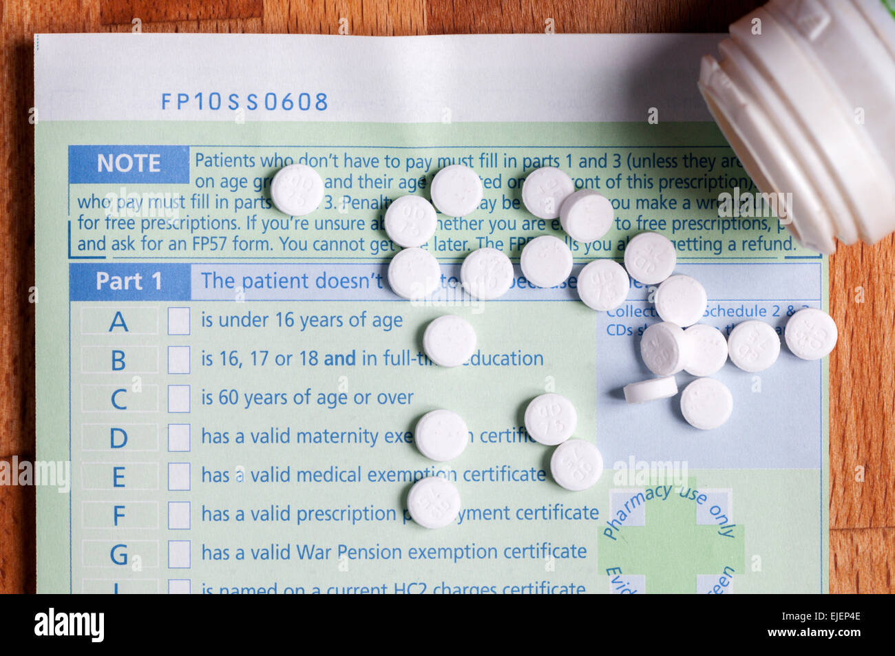 White pills spilt from a jar on a prescription. Stock Photo