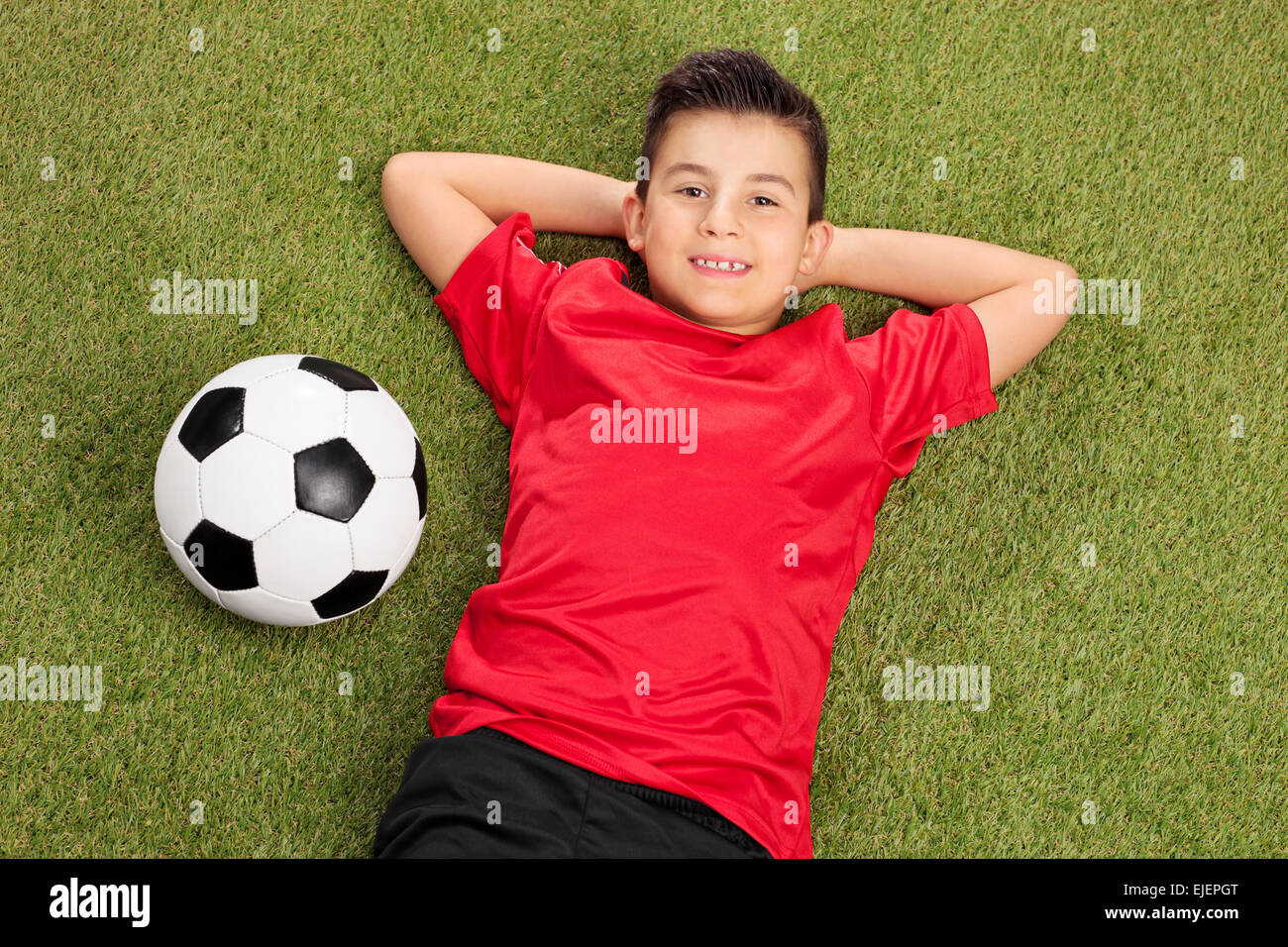 Carefree little boy in a red football 