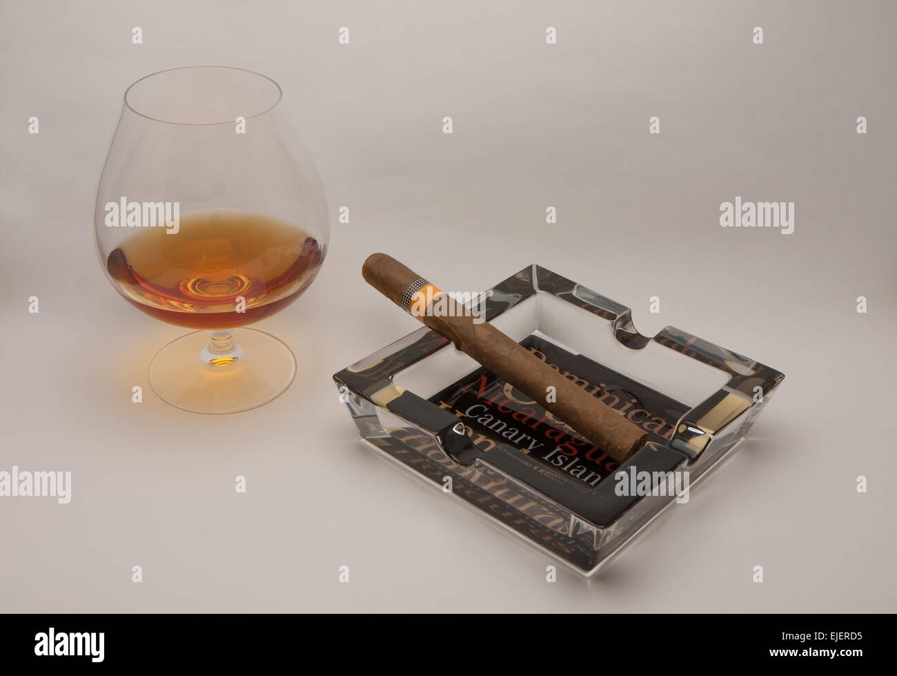 still life glass of brandy and Cuban cigars Stock Photo