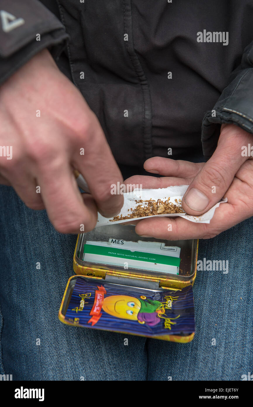 A man rolling a joint using Happy Joker, a Legal High Stock Photo