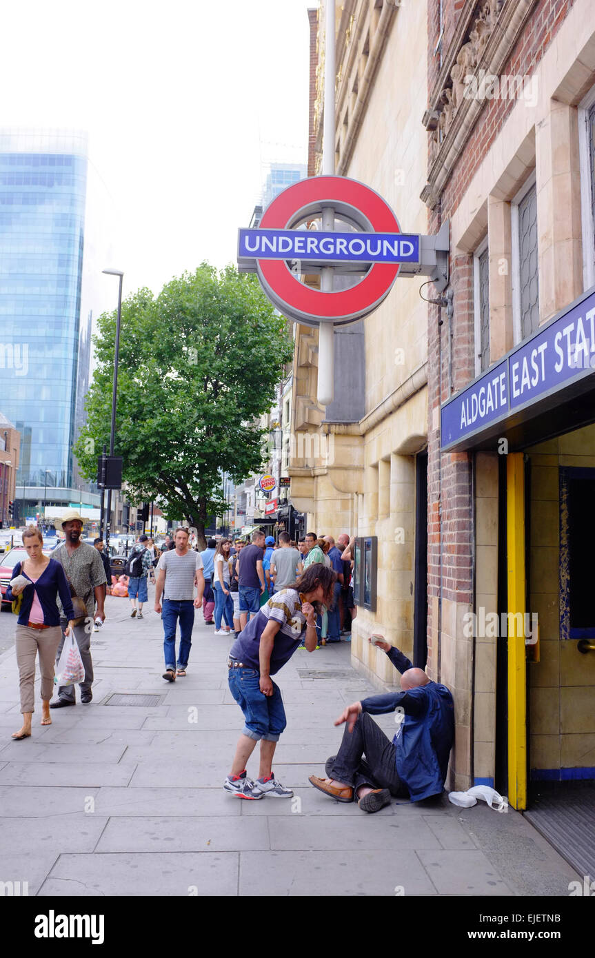 woman hitting a homeless man with a banana outside underground Station in London Stock Photo